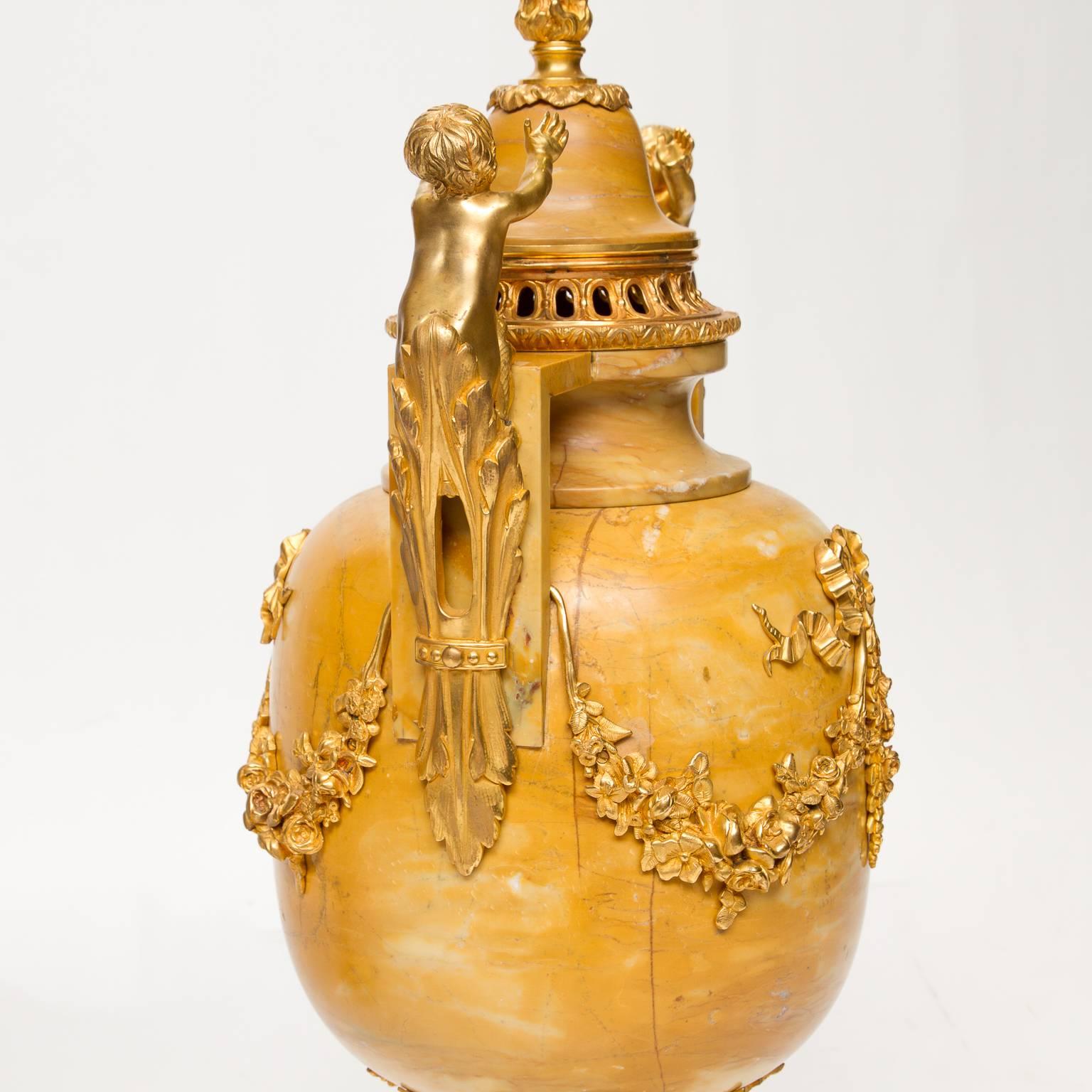 Une grande paire d'urnes en marbre (Hauteville) de style Louis XVI avec des montures en bronze doré très ordinaires. Les montures (excellent état et couleur) supportaient des putti, des pointes de flamme sur les CAP, jusqu'aux guirlandes à l'avant