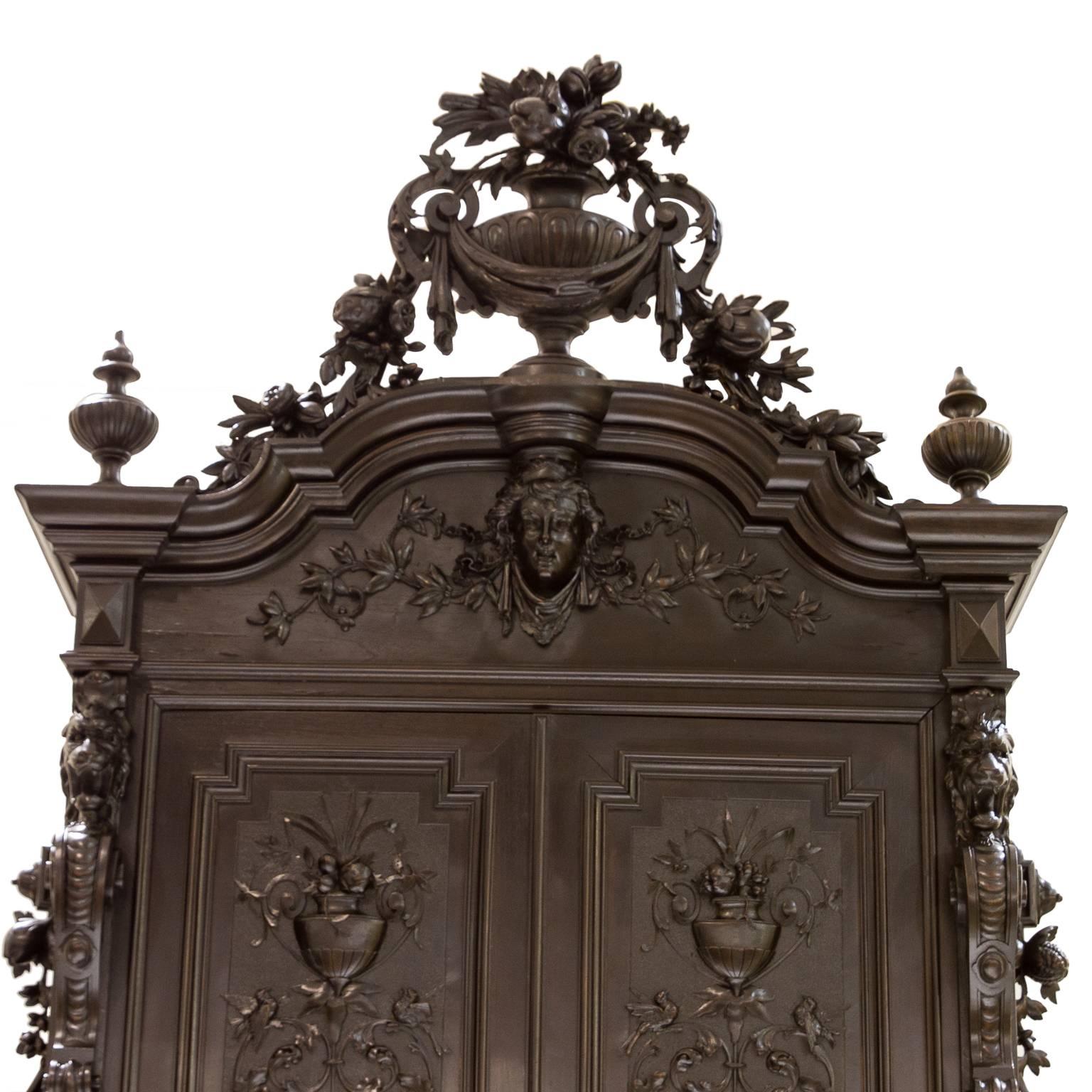 An astounding French Renaissance walnut cabinet with superb detailed carvings. This piece is not only striking but its large. The top has a very elaborate carved pediment (removable for transport) and flanked by two large finials. The panel below is