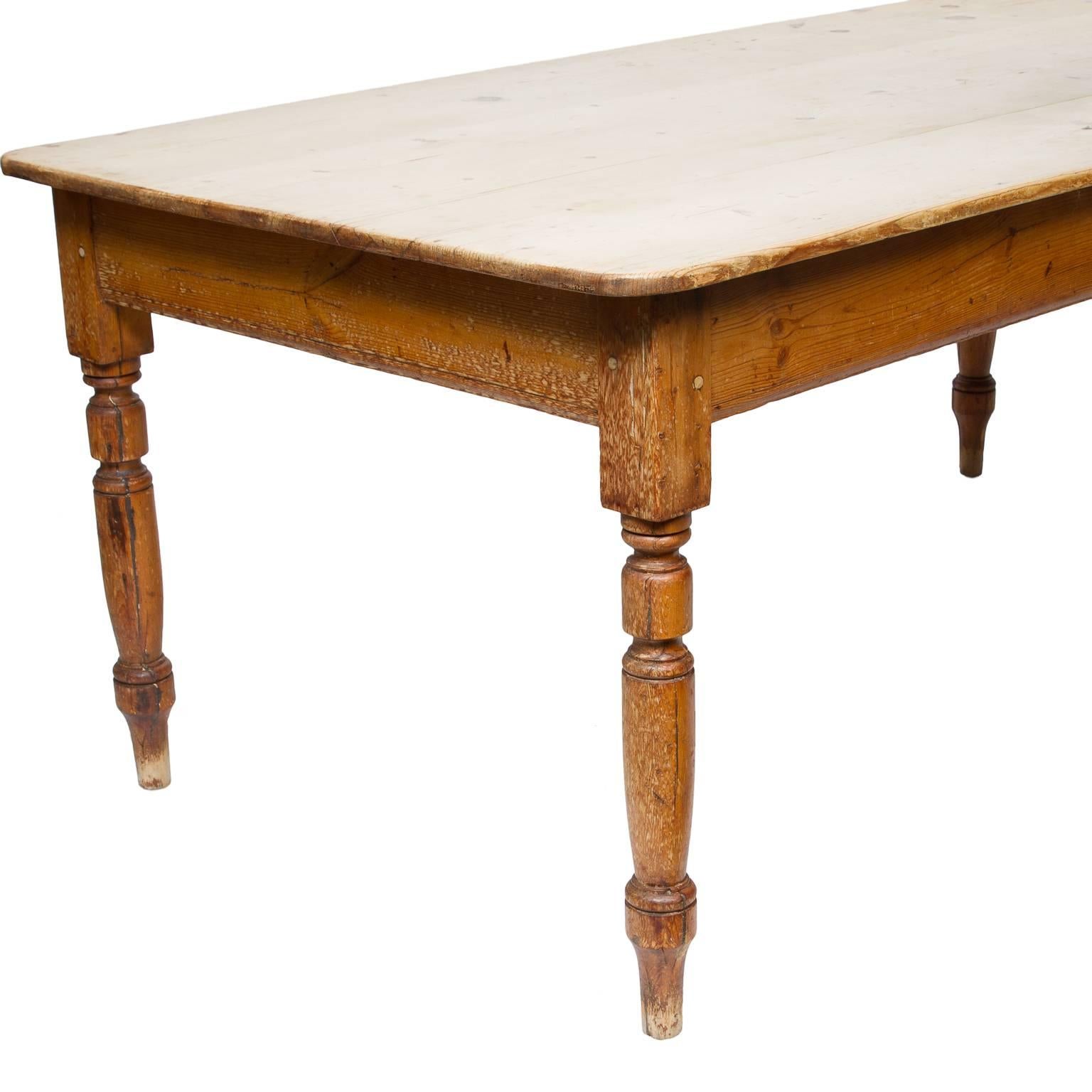 A fantastic 19th century pine farm table from England. There are four turned legs supporting an incredible scrub pine top. Beautiful English pine furniture, circa 1880s.