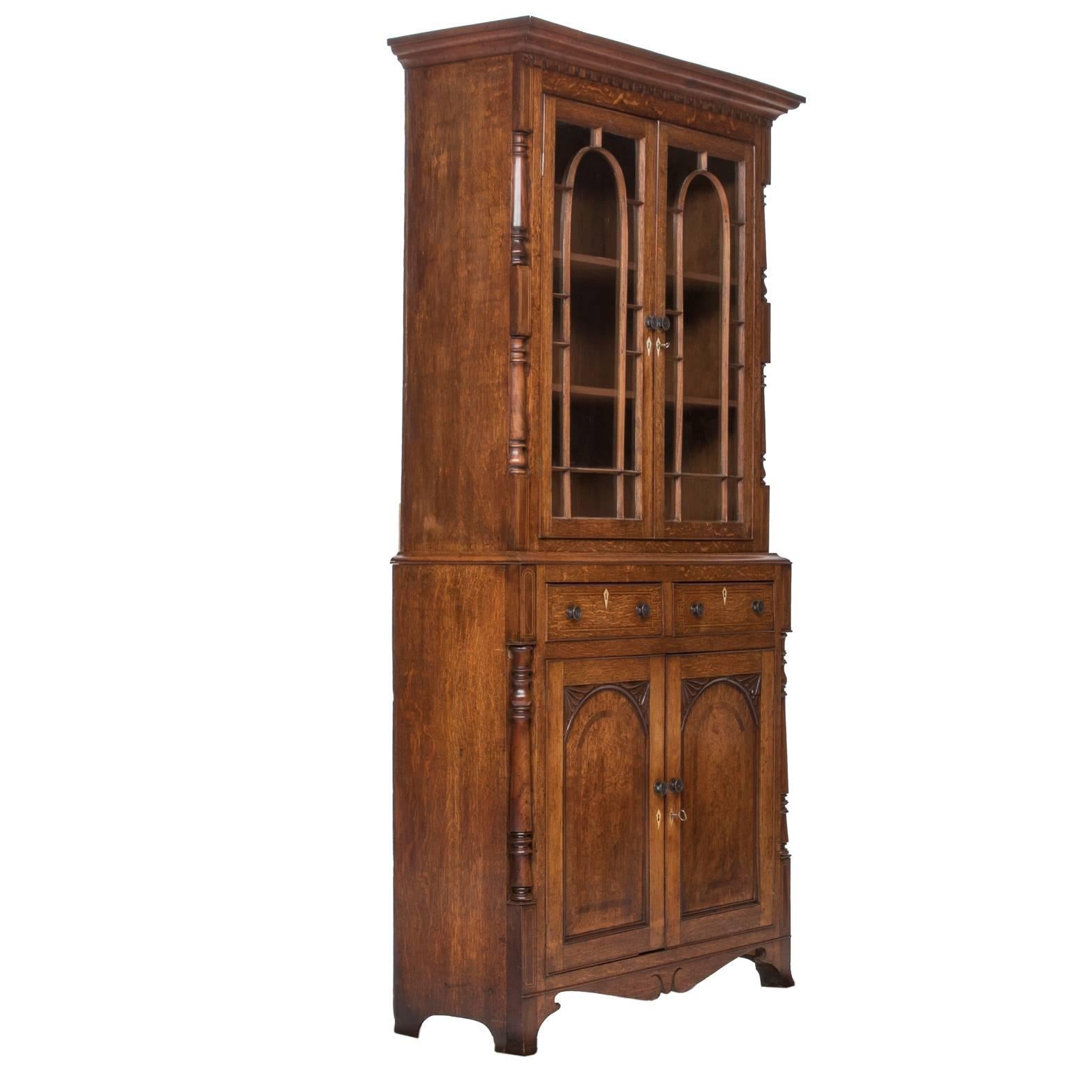 Lovely early 19th.c. North Welsh oak glazed cupboard c.1820. Two doors glazed top with two shelves over a cupboard base with two drawers in the waist. Lots of good detail here with a flared cornice with dental carving, astragal glazed doors, inlaid
