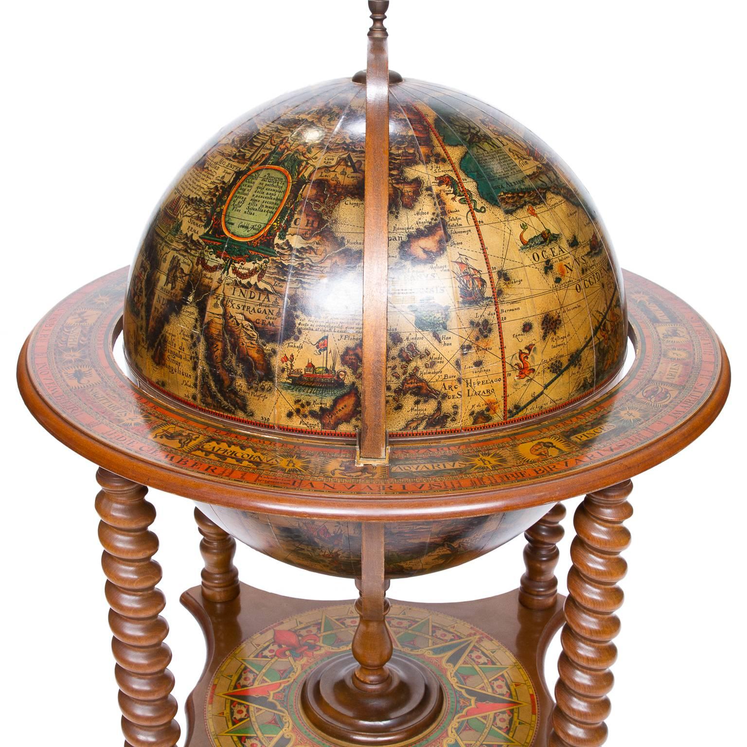 A nice vintage decorated globe on stand and opening to reveal a fitted bar storage complete with ice container. The printed color map is in 12 sections and multiple colors. The rim and lower platform also with paper layouts of 