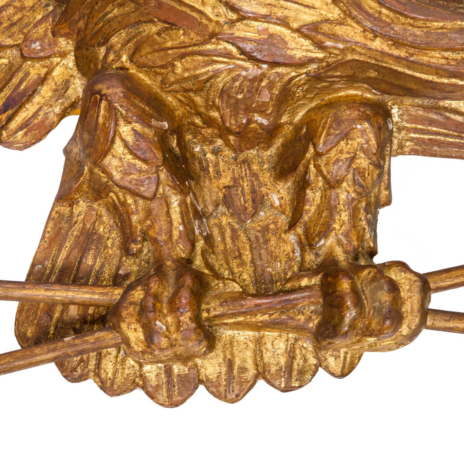 A fine Italian carved giltwood eagle holding arrows by Palladio.