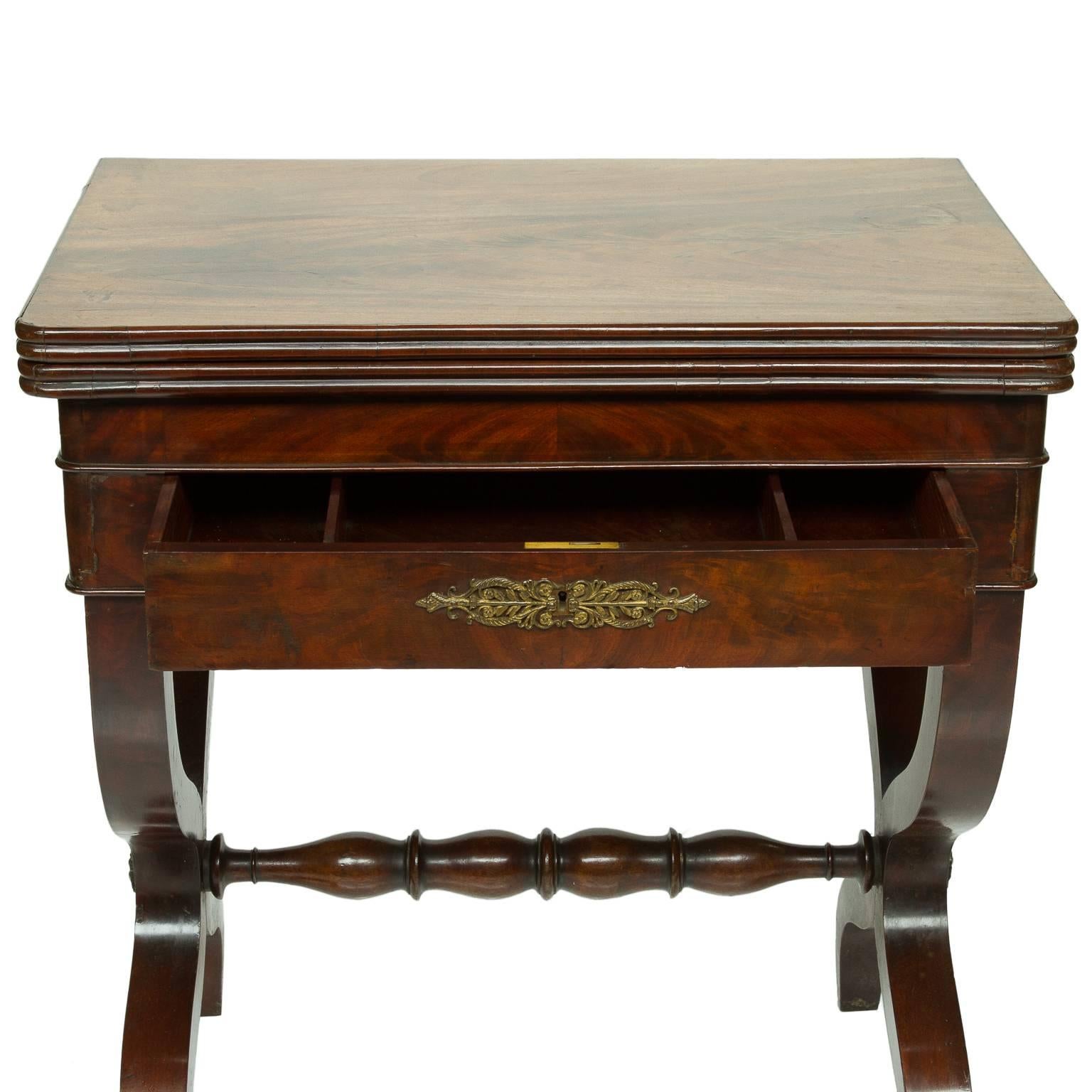 Lovely little early 19th century foldover card table of continental origin, circa 1820. Stands flat against the wall as a handsome little console table, just 26″ wide. Rotate and fold open the top to reveal a green baize playing surface for cards