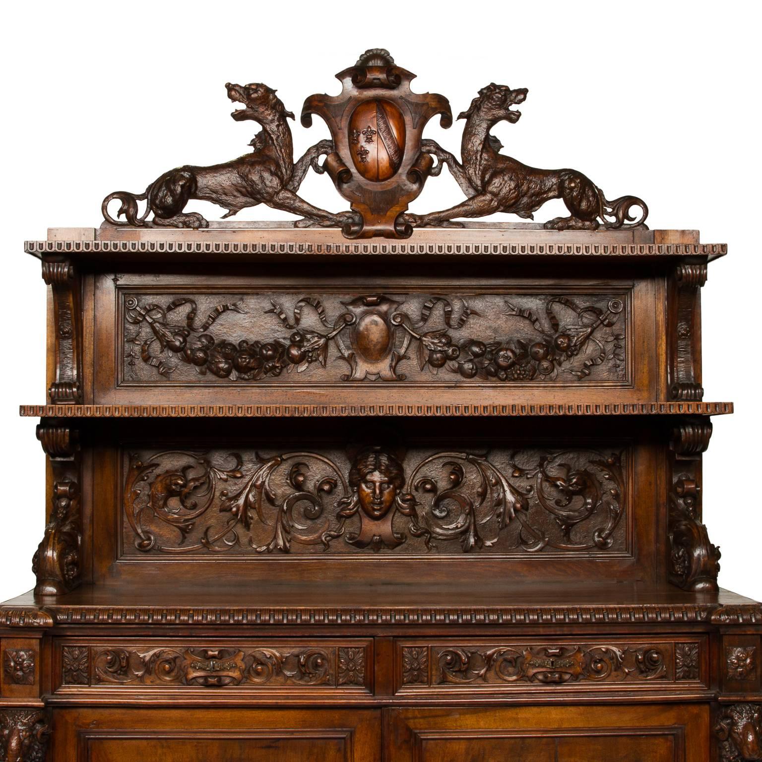 This cabinet is an archetype model of hunting lodge furniture. The wood and detail of the carvings exceed the quality that's typically associated with hunting lodge style furniture. This piece is topped with a coat of arms which is surrounded by two