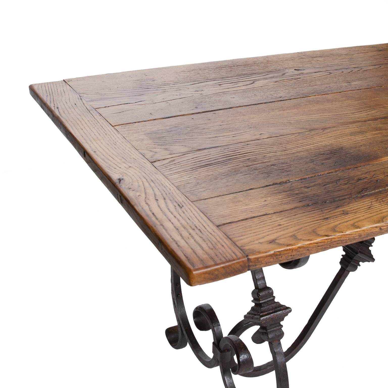 A fantastic iron base dining table from England. The top which is made of reclaimed timber accents the base. This table was made from two other antique tables which were combined to create an outstanding dining table. Top is from the late 19th