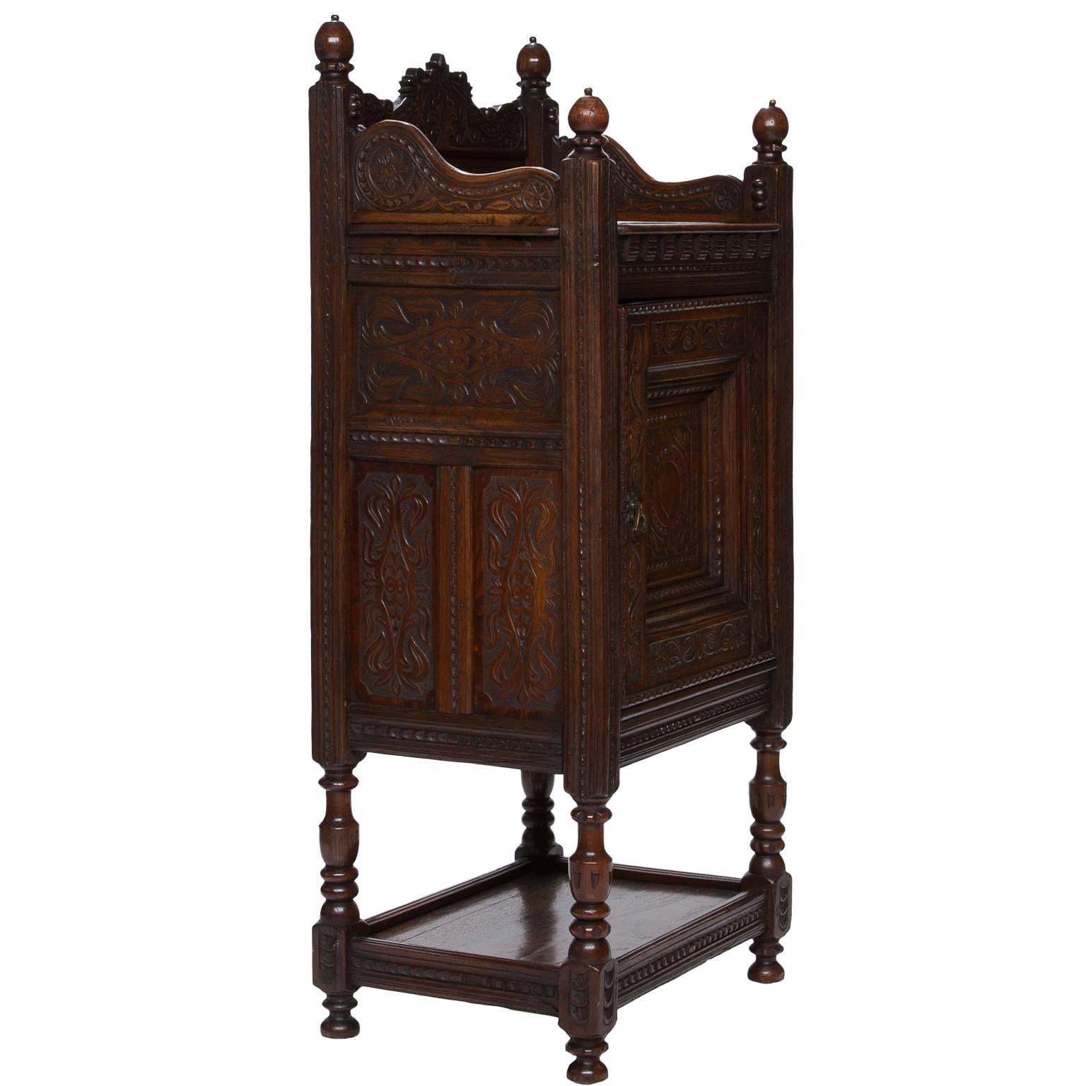 A strong 18th century carved single door cabinet with shelf above and below the cabinet section. This piece has a pleasant shellac finish. Turned legs connected with a box stretcher, circa 1790