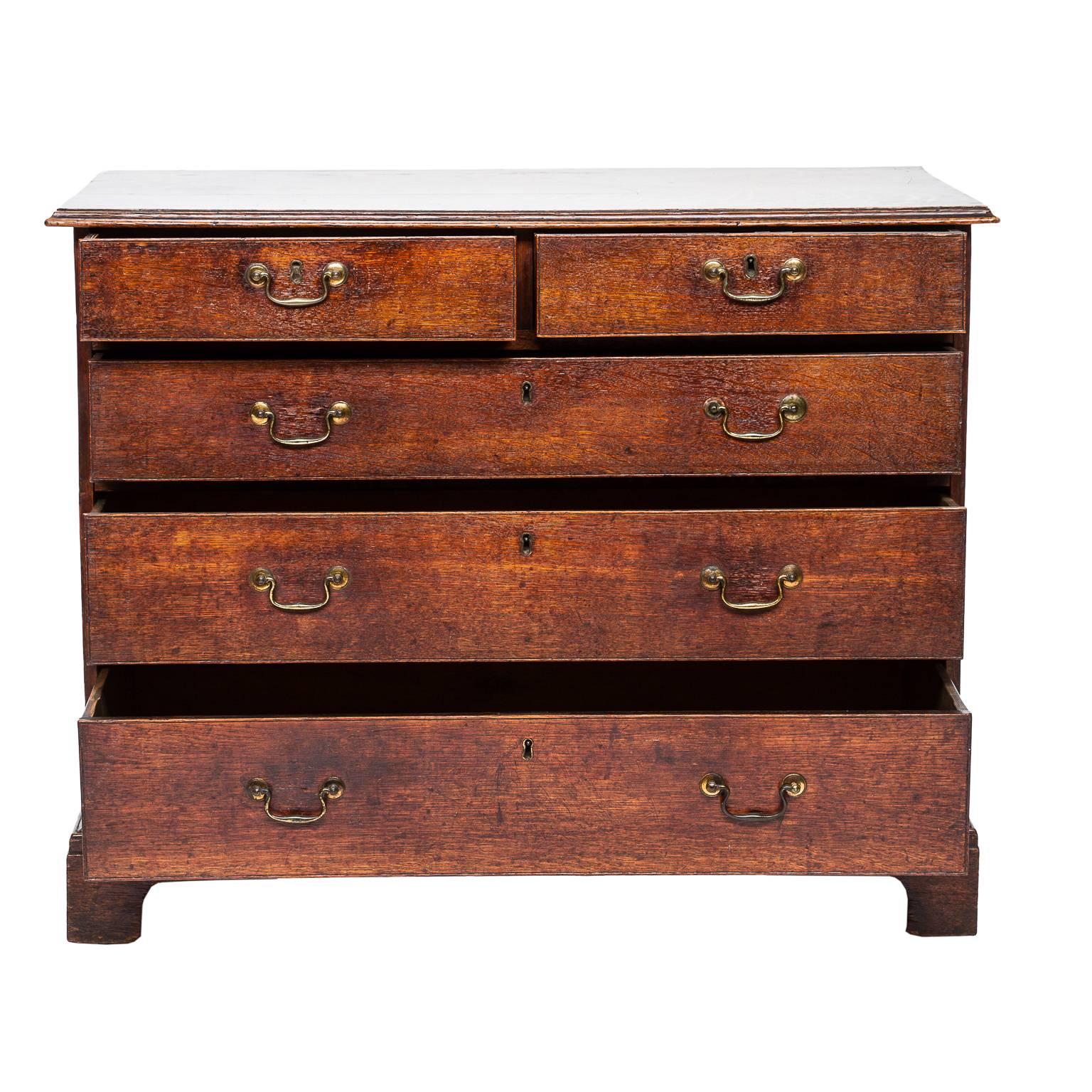 A very nice English two over three chest of drawers made from quarter sawn oakwood. This chest has wonderful simple look. Nice bracket feet and worn brass bail pulls, circa 1840.