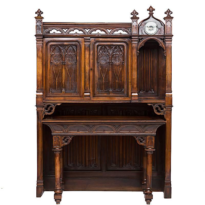 This is an impressive 19th century cabinet and table with a clock. The table pulls away from the cabinet portion. There are two doors in cabinet portion opening to reveal two shelves (to store hymnals). Next to the two doors is an arched opening and