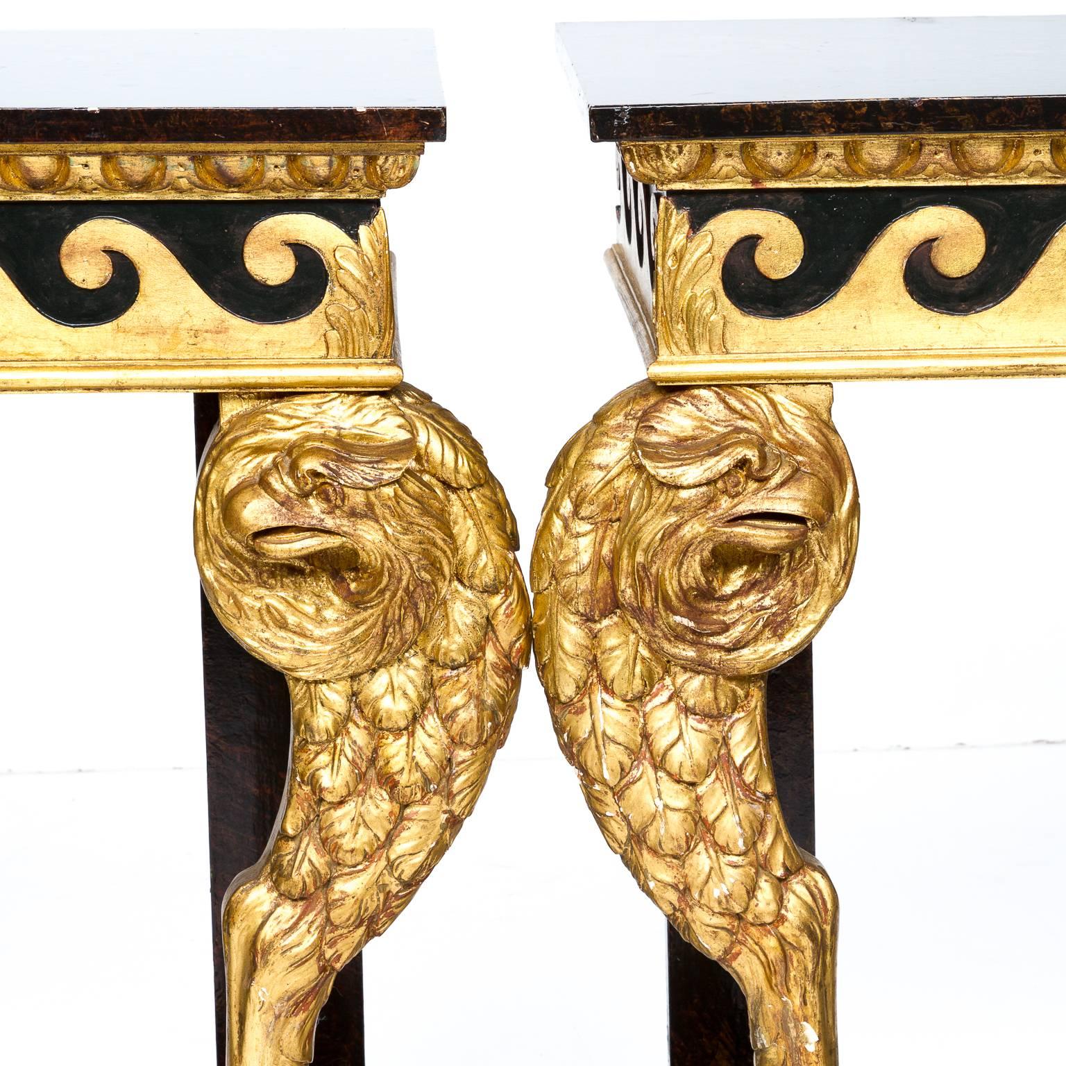 A pair of continental faux marbleized black with red veining consoles. Notice the quality and detail worked into the supports. A highly hand-carved feathered eagle ending in a claw and ball foot. A gold leaf finished scroll applied and an egg and