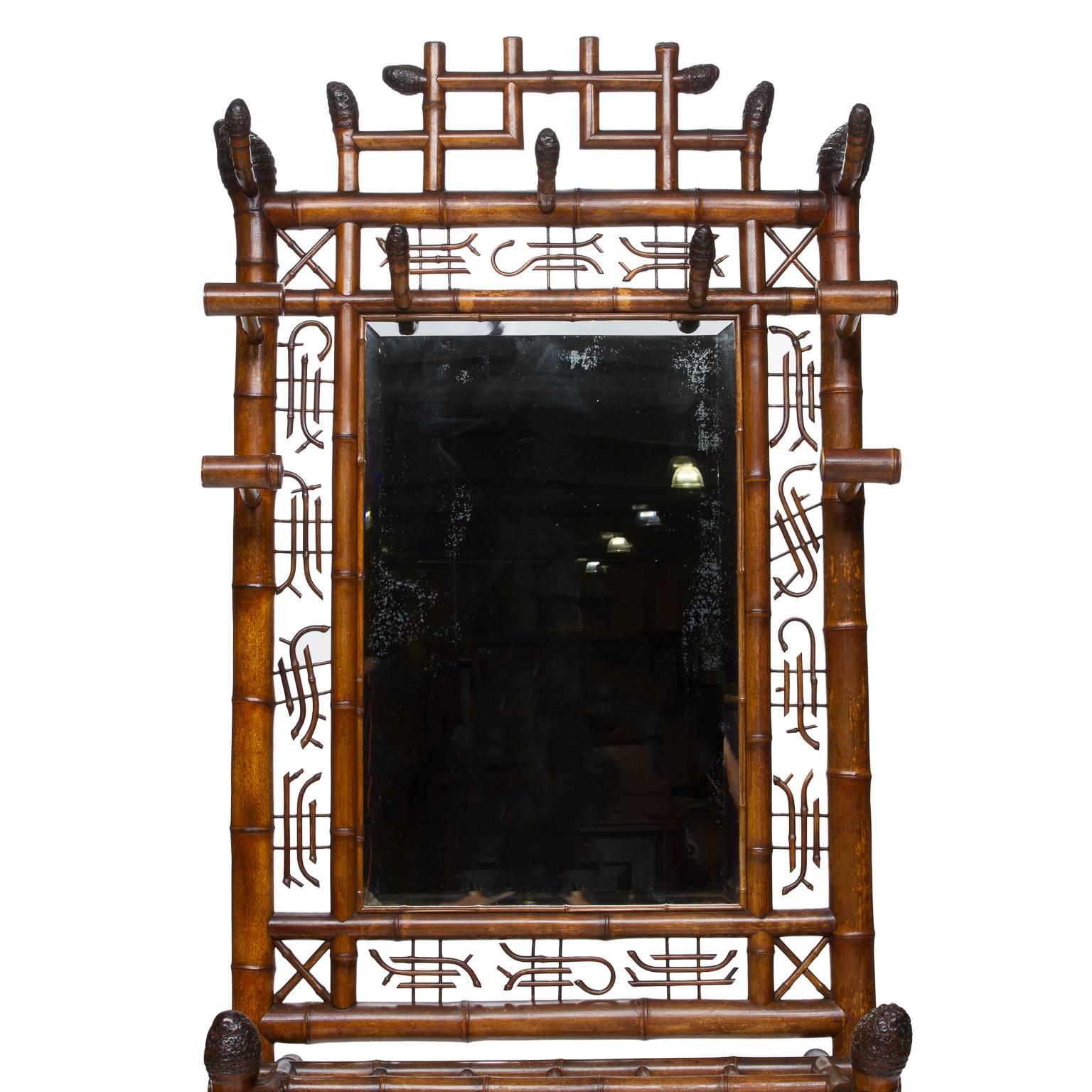 Bamboo constructed hall tree with a mirror surrounded by script suspended with wooden dowels. Hat and coat supports. Wonderful patina and aging of the mirror too. Very nice quality, the carved ends of the supports the workmanship to evenly suspend