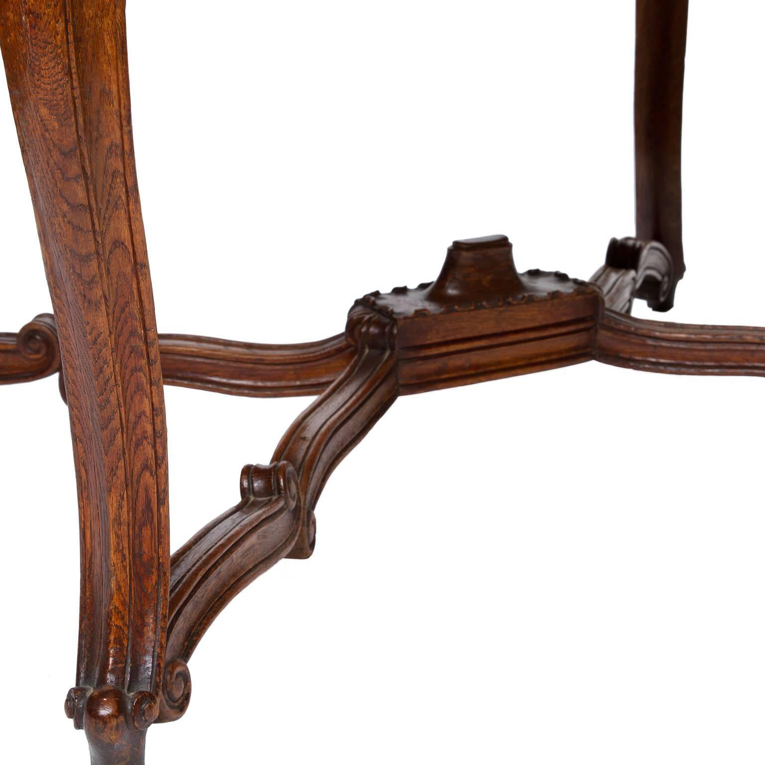 A French country dining table from the Normandy region of France. The Louis XV style dining table has ends that pull-out and will support leaves (no leaves with the table). However closed these ends have nice heavy bronze handles. Parquetry top