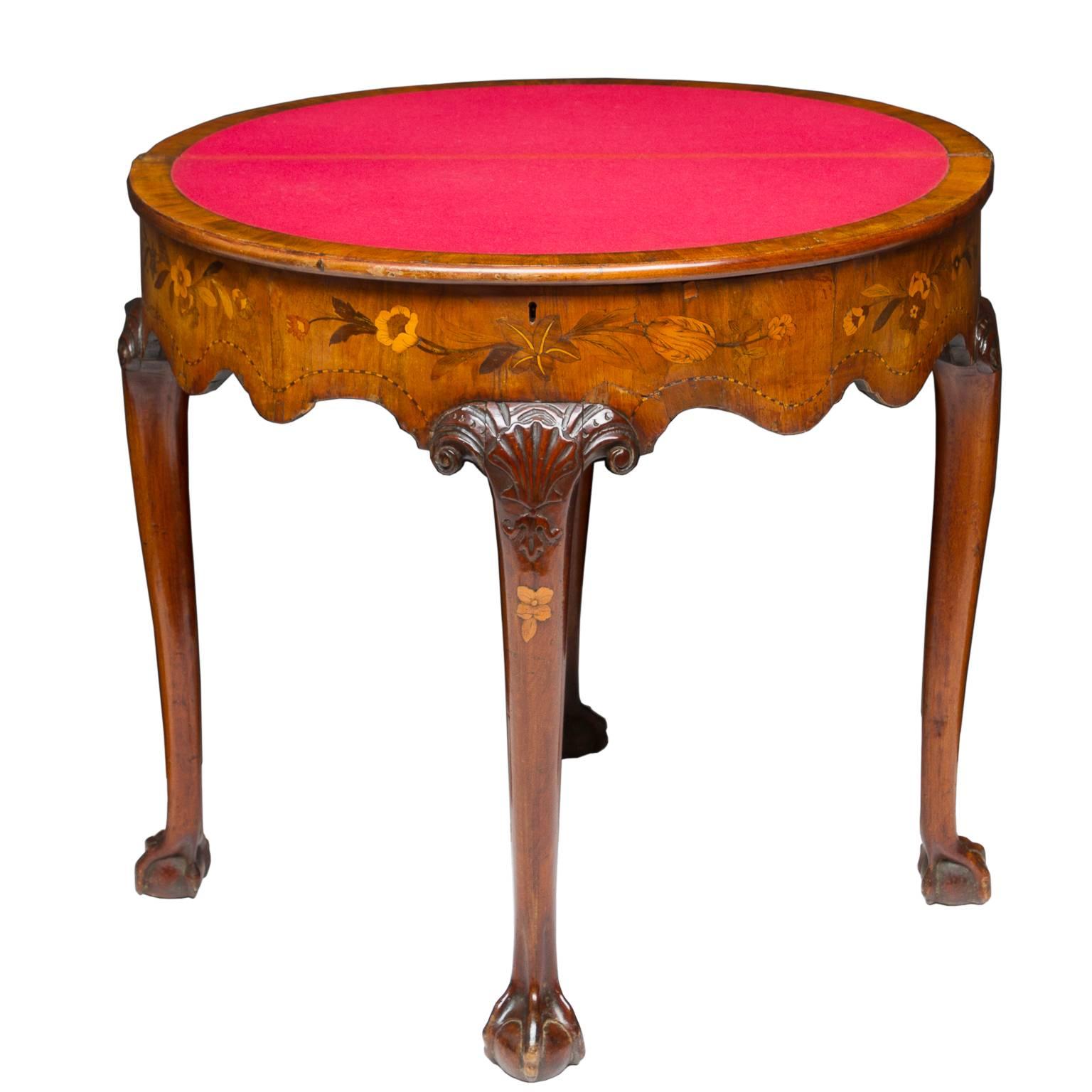 A spectacular and luxurious finished, Dutch marquetry inlaid flip-top game table. This piece is Chippendale style resting on the walnut cabriole legs ending with a claw and ball foot. Notice the shell carvings and the inlay into the leg. Superb!