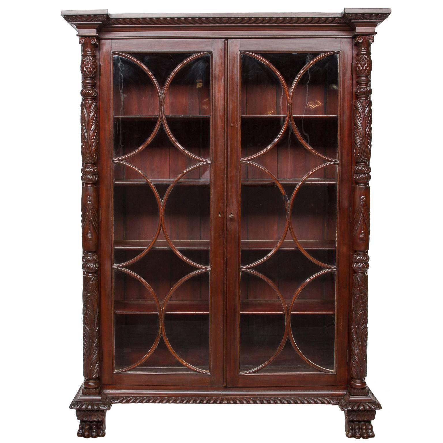 A fantastic 19th century English mahogany display cabinet. Exceptional carved columns and moldings. Distinctive sash with individual panes of glass. Original interior shelves ready for display. Carved lion paw feet. Very impressive cabinet in the