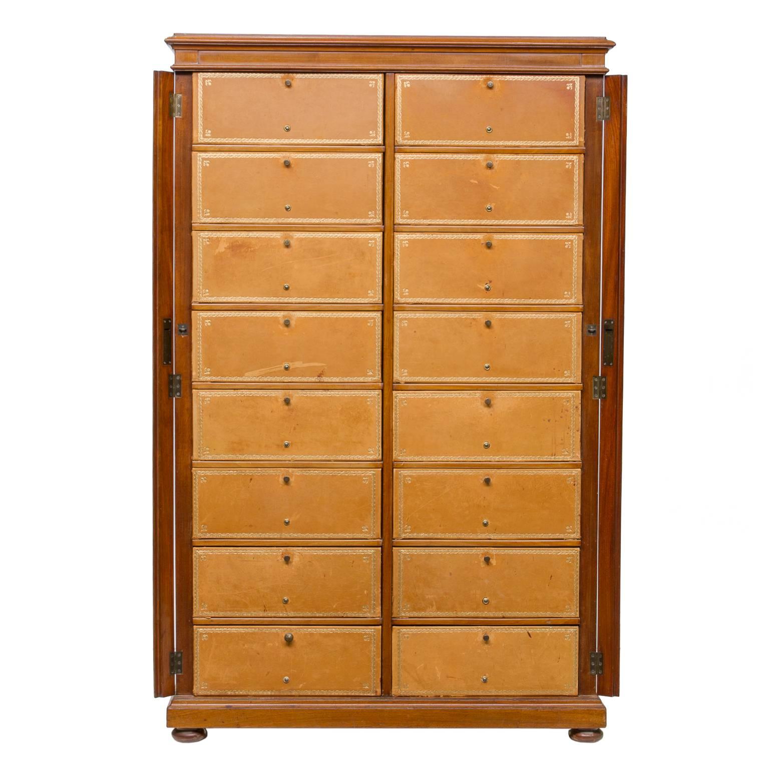 English mahogany file cabinet with two vertical rows of embossed leather fronted boxes. Each front drops to reveal nice size storage. Great for shoes or other items. The body is made of fine mahogany wood, very solid. This piece has had fading occur