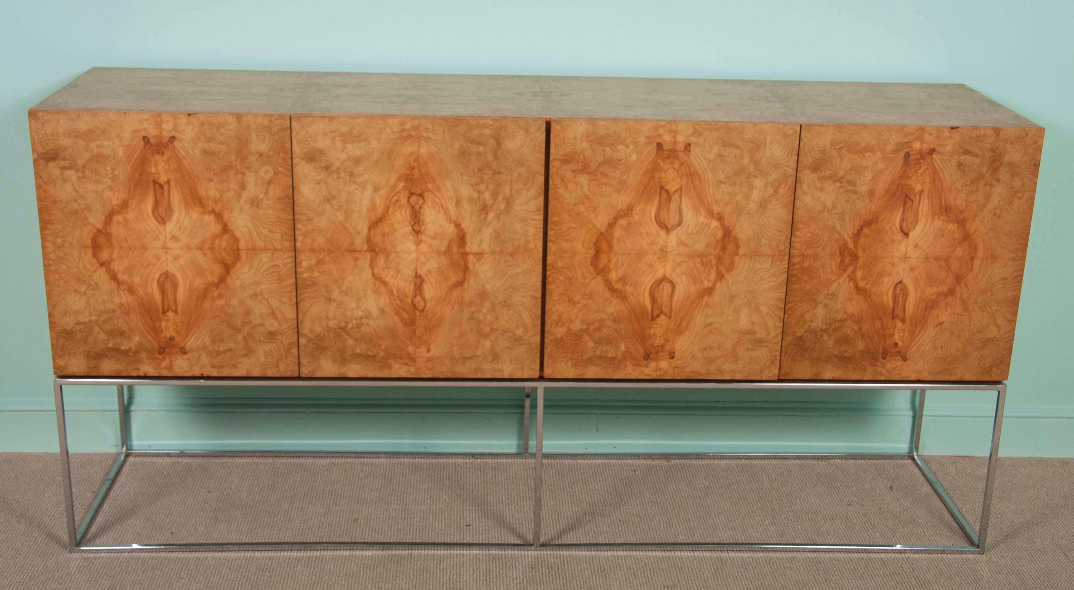 Offered for your consideration is a striking Milo Baughman for Thayer Coggin sideboard or credenza in bookmatched burled olive wood veneer floating above a slim chrome base.
The piece is a beautiful statement piece from the 1970s by one of the
