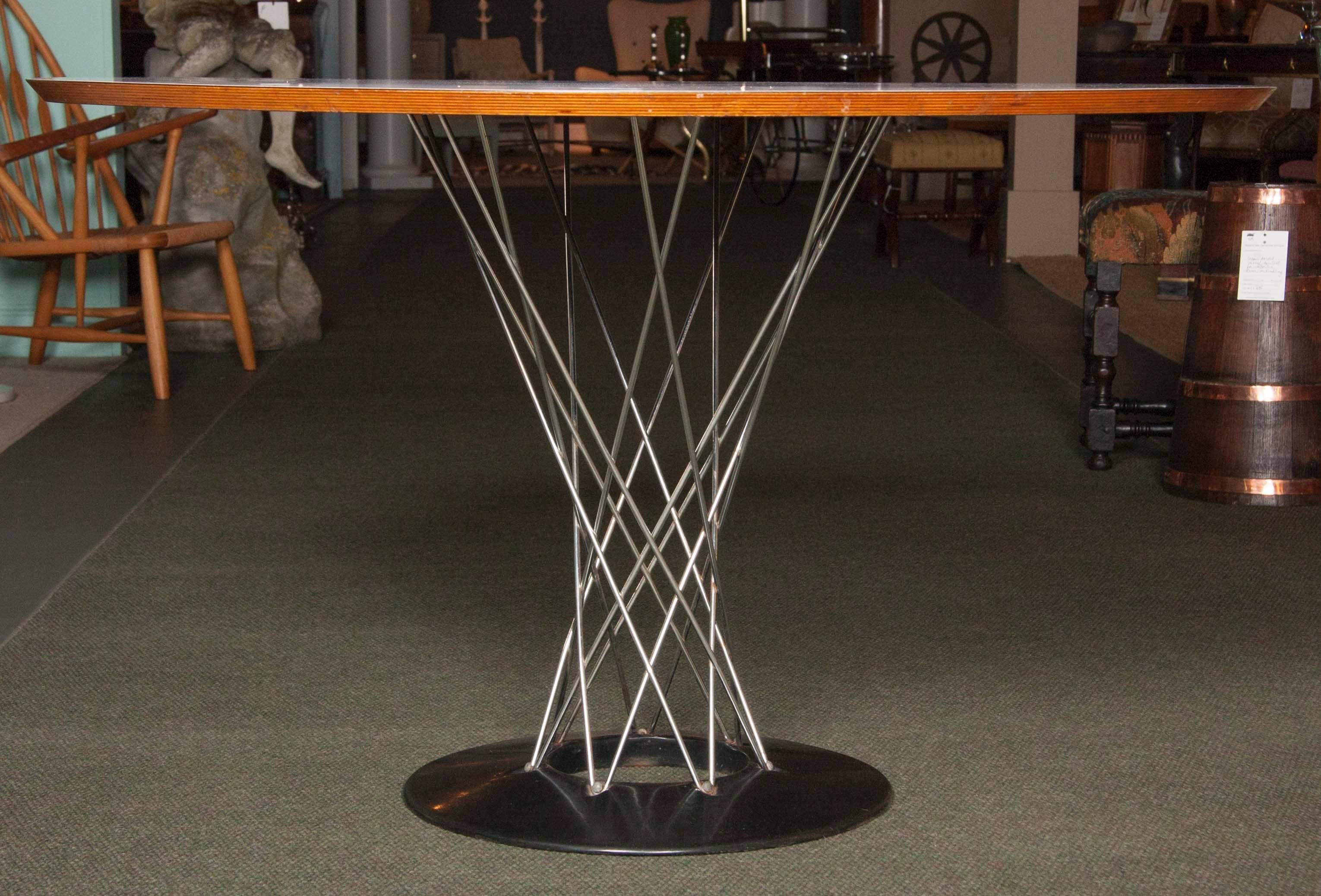 Offered for your consideration is an early “Cyclone” table by the famed Mid-Century designer Isamu Noguchi for Knoll. The table derives its name from the twisted wire base that curves out from the porcelain coated cast iron base. The top is made of