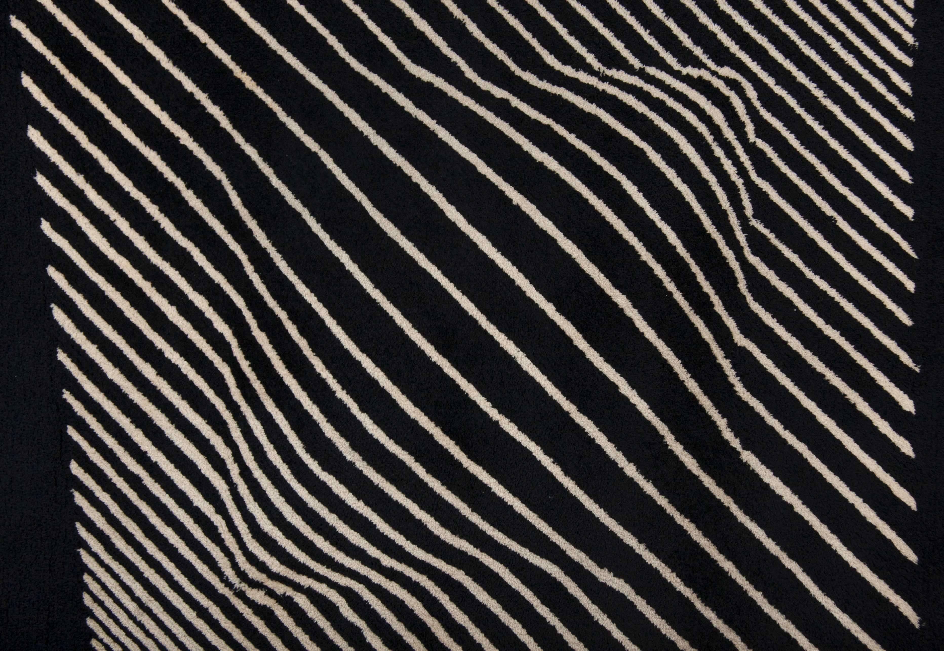 A hand-knotted wool tapestry after Victor Vasarely, signed with applied manufacturer's label to verso 