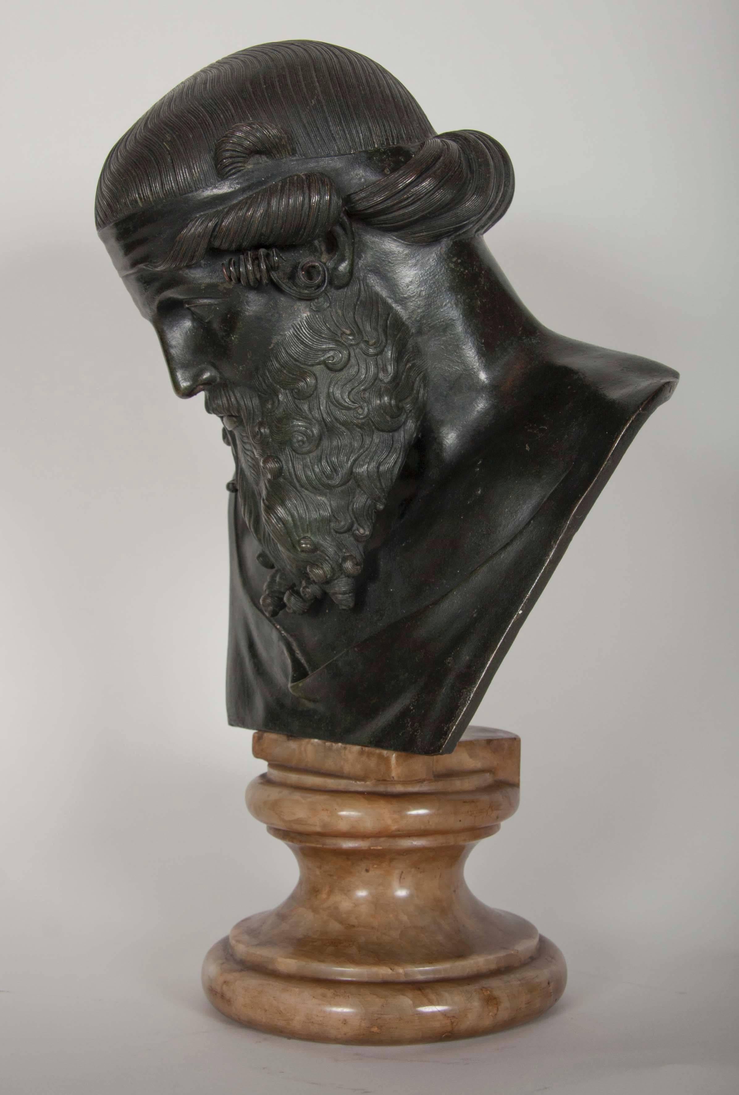 A patinated green bronze bust of Zeus on a variegated marble socle.

