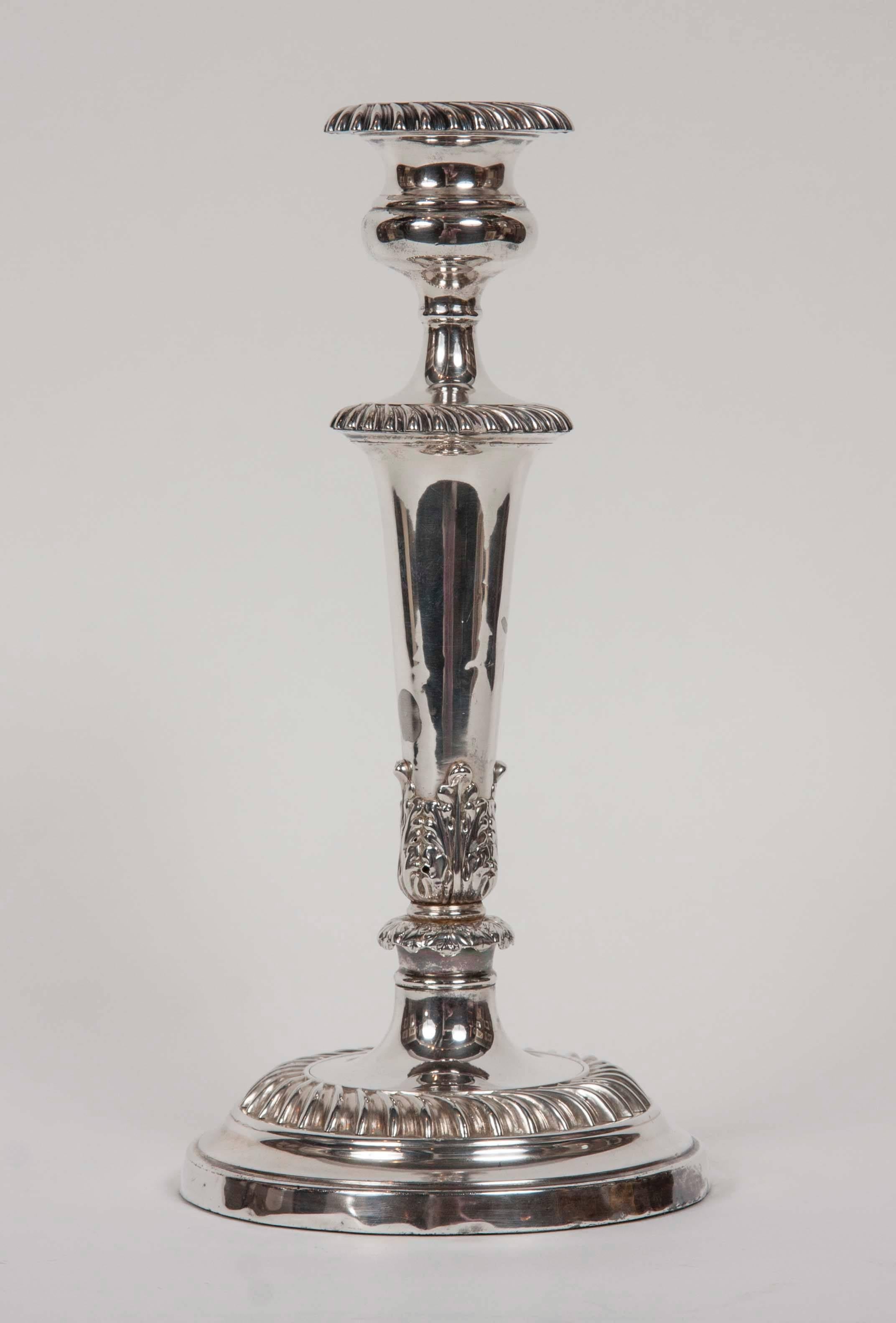 A set of four single candlesticks, marked 950 silver with circular bases and an acanthus design on the base of the column support.