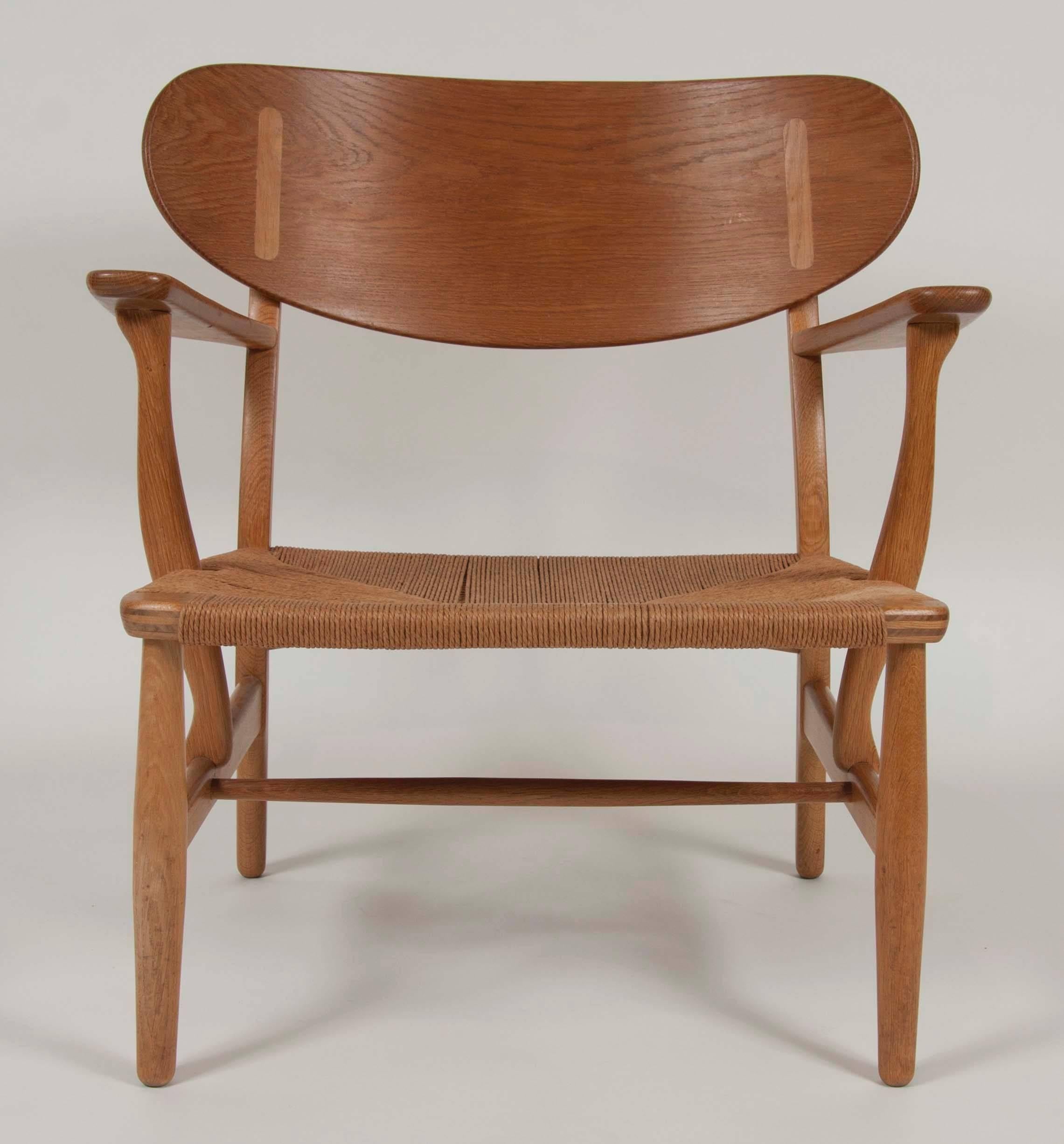 Oak armchair with wide paddle form arms and sculpted and inlaid back. Also having a Danish paper cord seat. The chair was designed by Hans J. Wegner and manufactured by Carl Hansen & Søn, 1951.