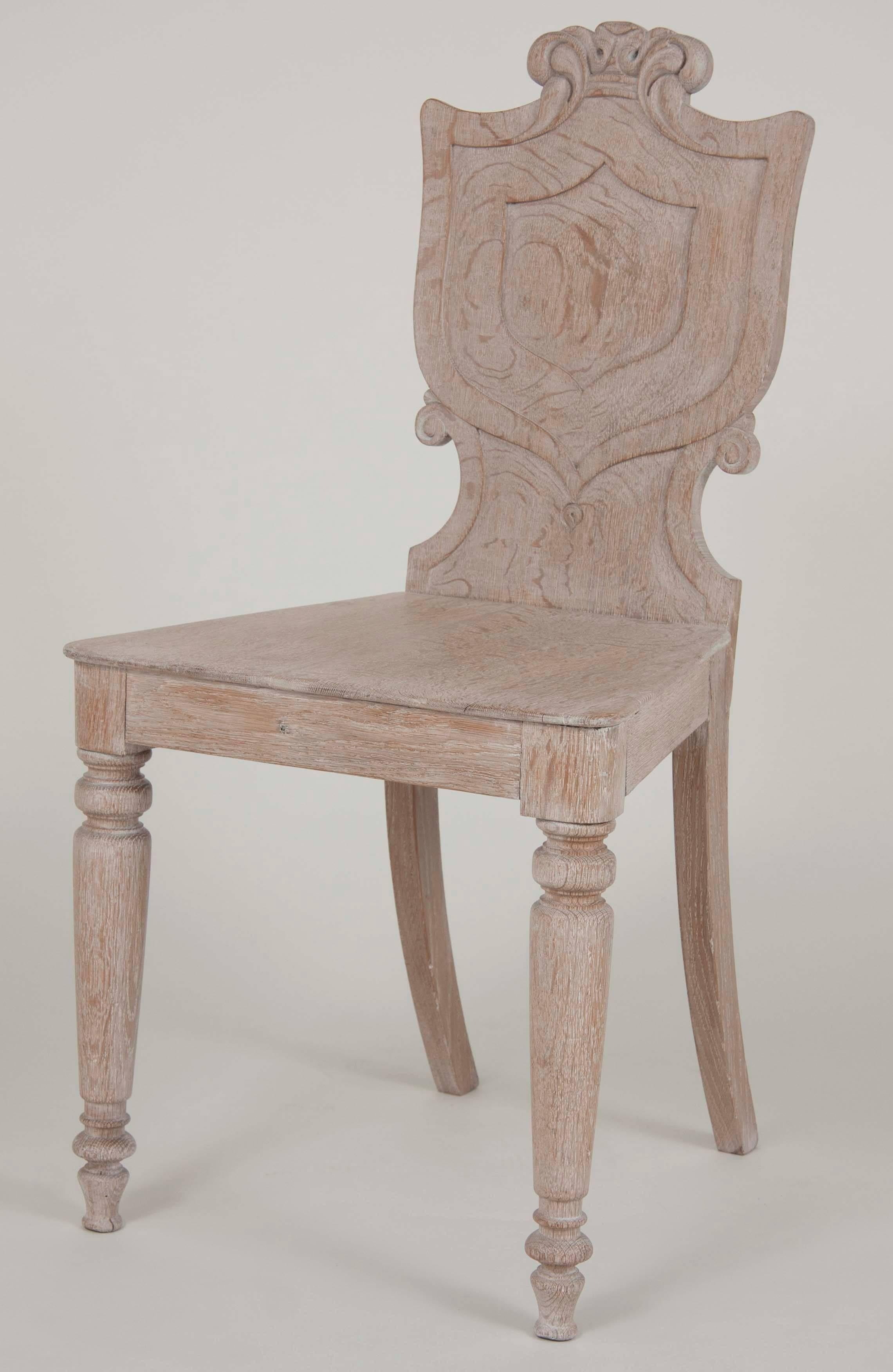 A set of four English limed oak hall chairs, circa 1880.