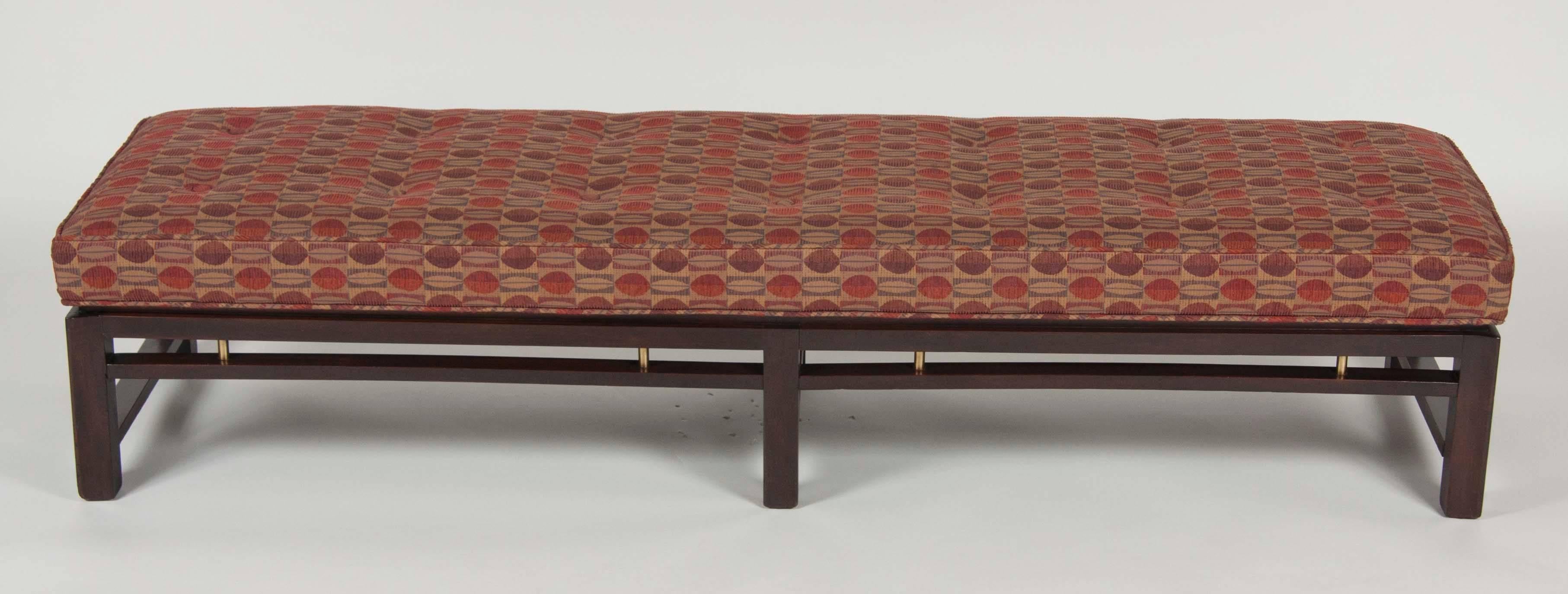 An Edward Wormley for Dunbar upholstered six leg mahogany bench with brass detail.