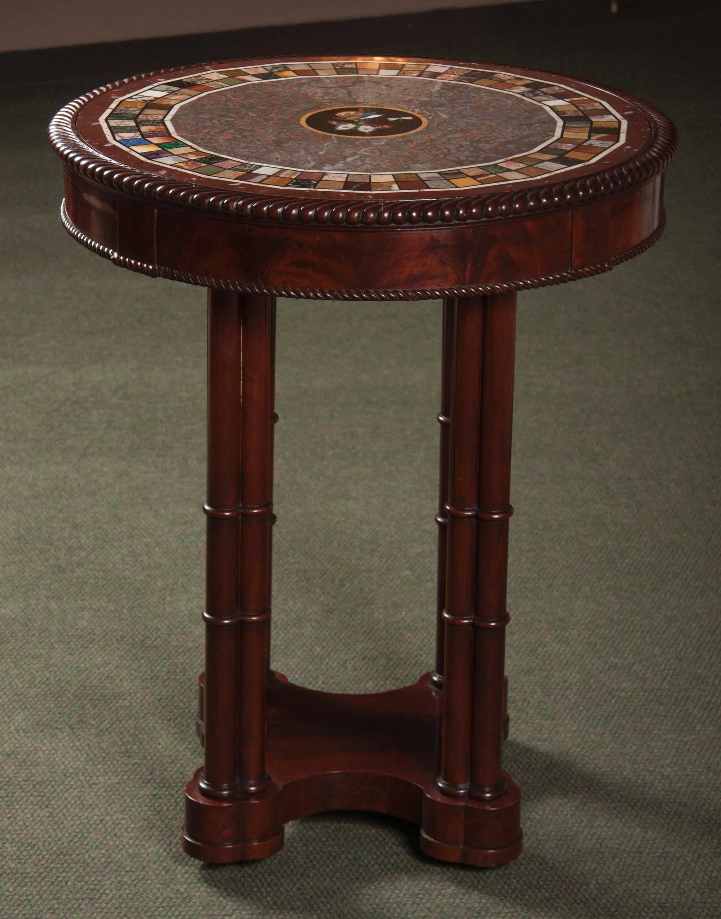 A small French, Charles X, mahogany center table on four column-shaped legs and an Italian specimen Pietra Dura marble top.
