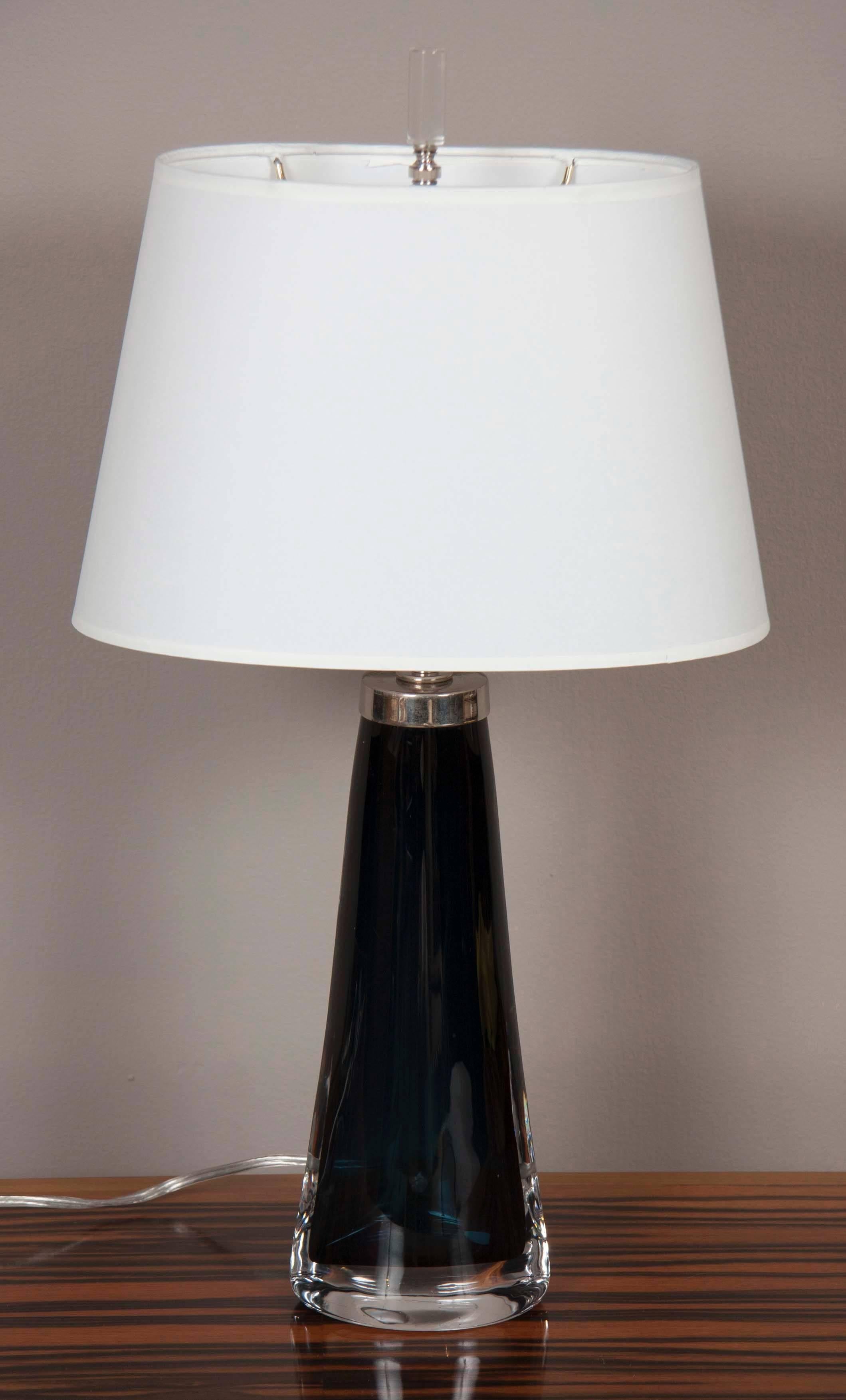 A beautiful glass table lamp by Nils Landberg for Orrefors having a dark blue interior and a clear exterior.
