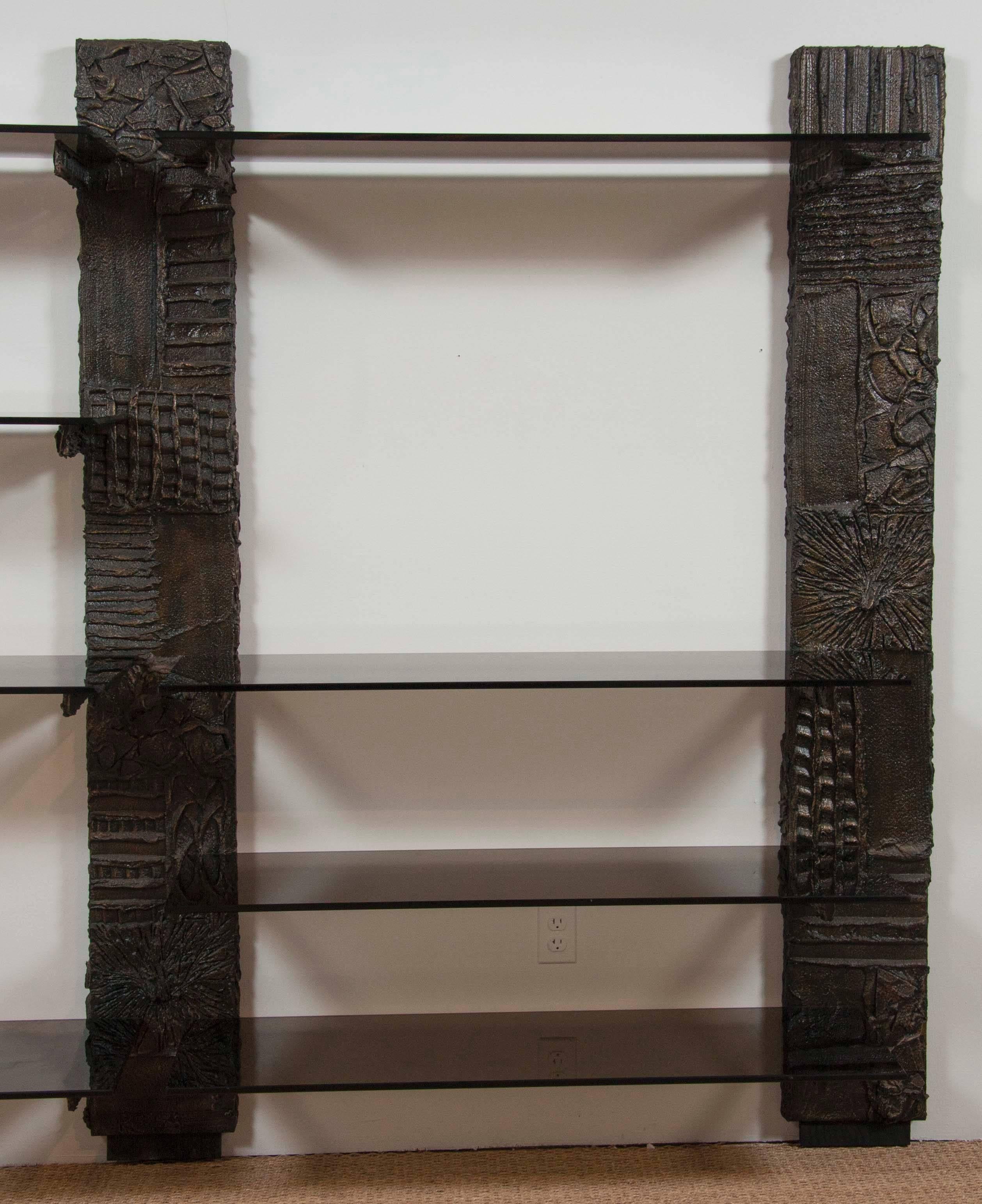 A Paul Evans Sculpted Bronze Series bookshelf with smoked glass shelves. Signed 