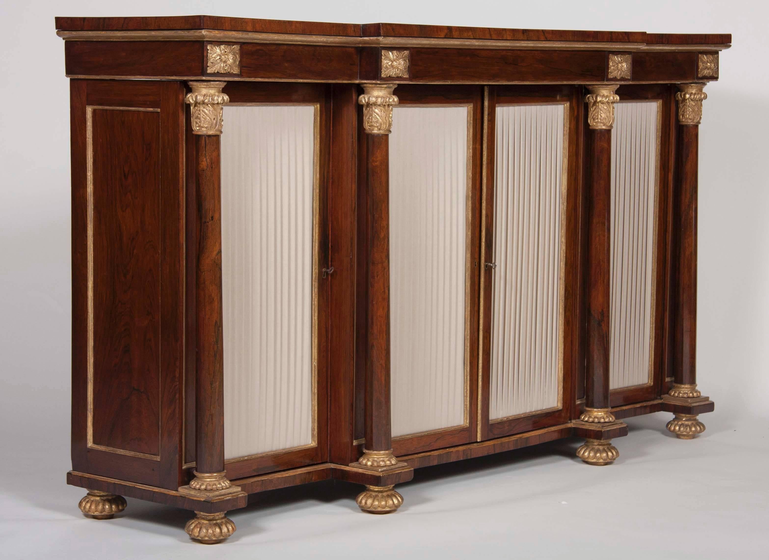 A wonderful English Regency rosewood credenza with gilt acanthus leaves surmounting vertical columns.