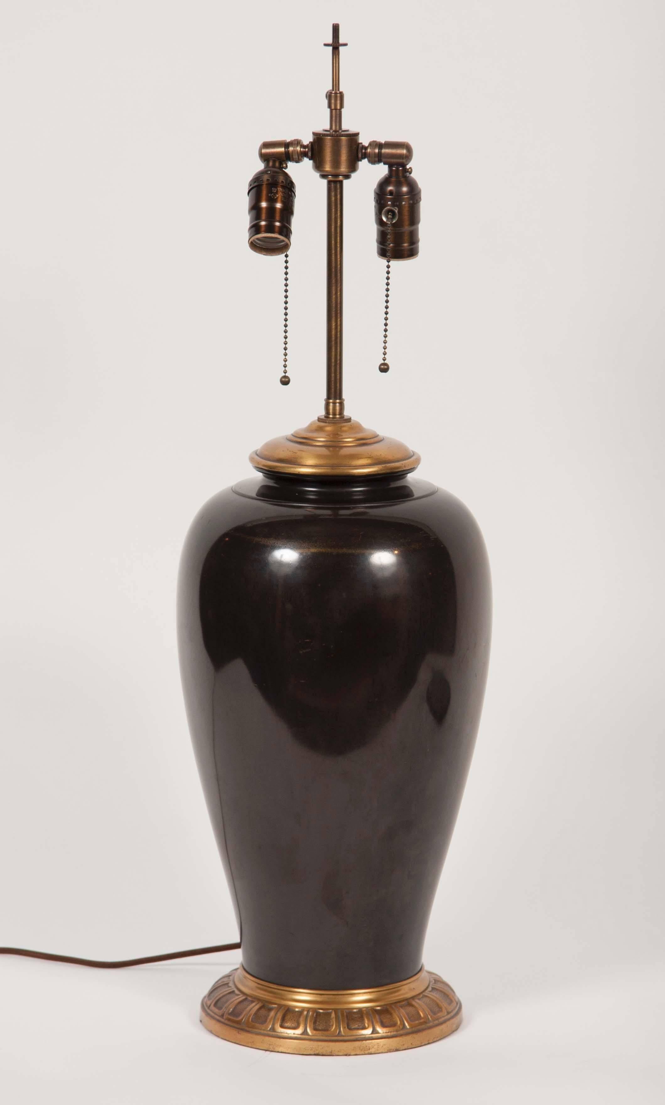 Large urn-shaped lamp having a round bronze base and CAP featuring a double light cluster.