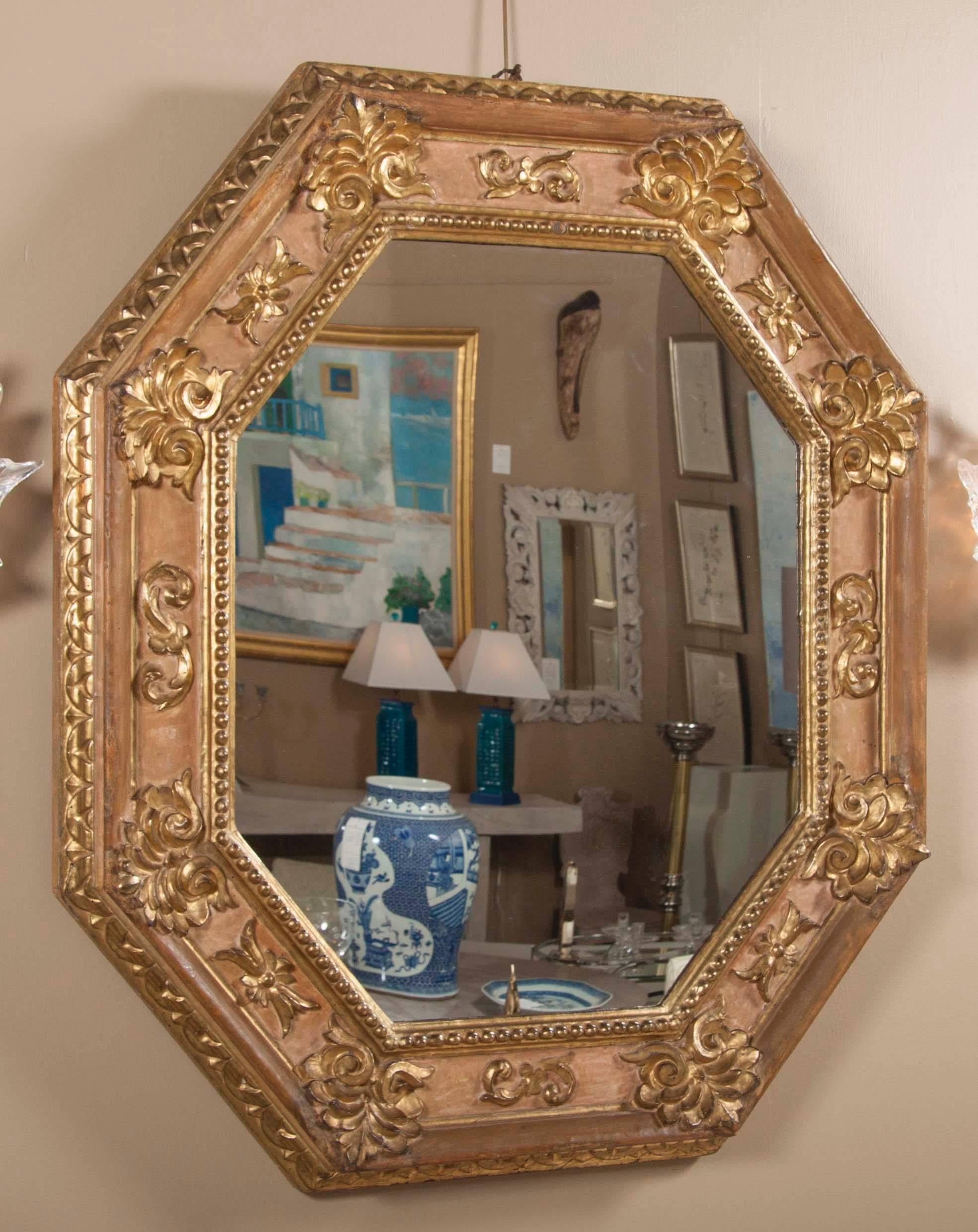 A handsome very early 18th century Italian carved and giltwood octagonal mirror.
