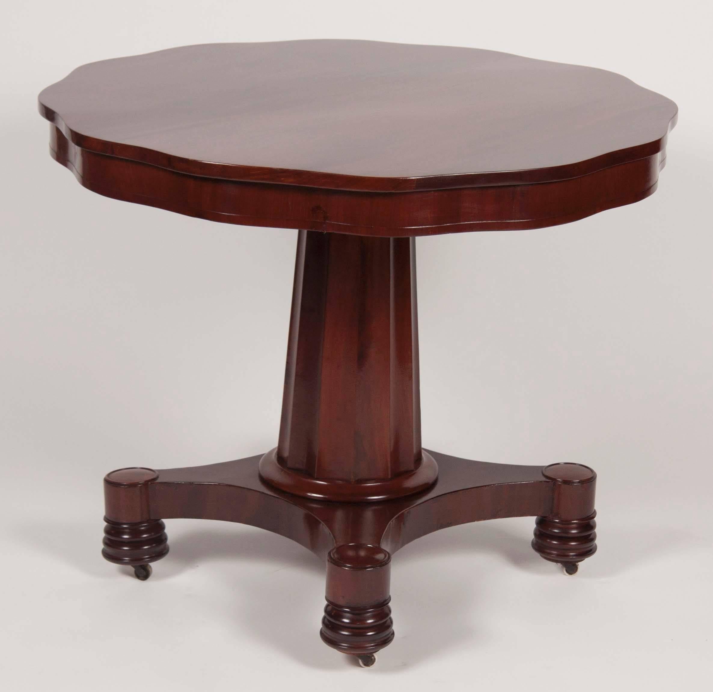 An American mahogany and mahogany veneer Empire table with interesting leave form and fluted base.