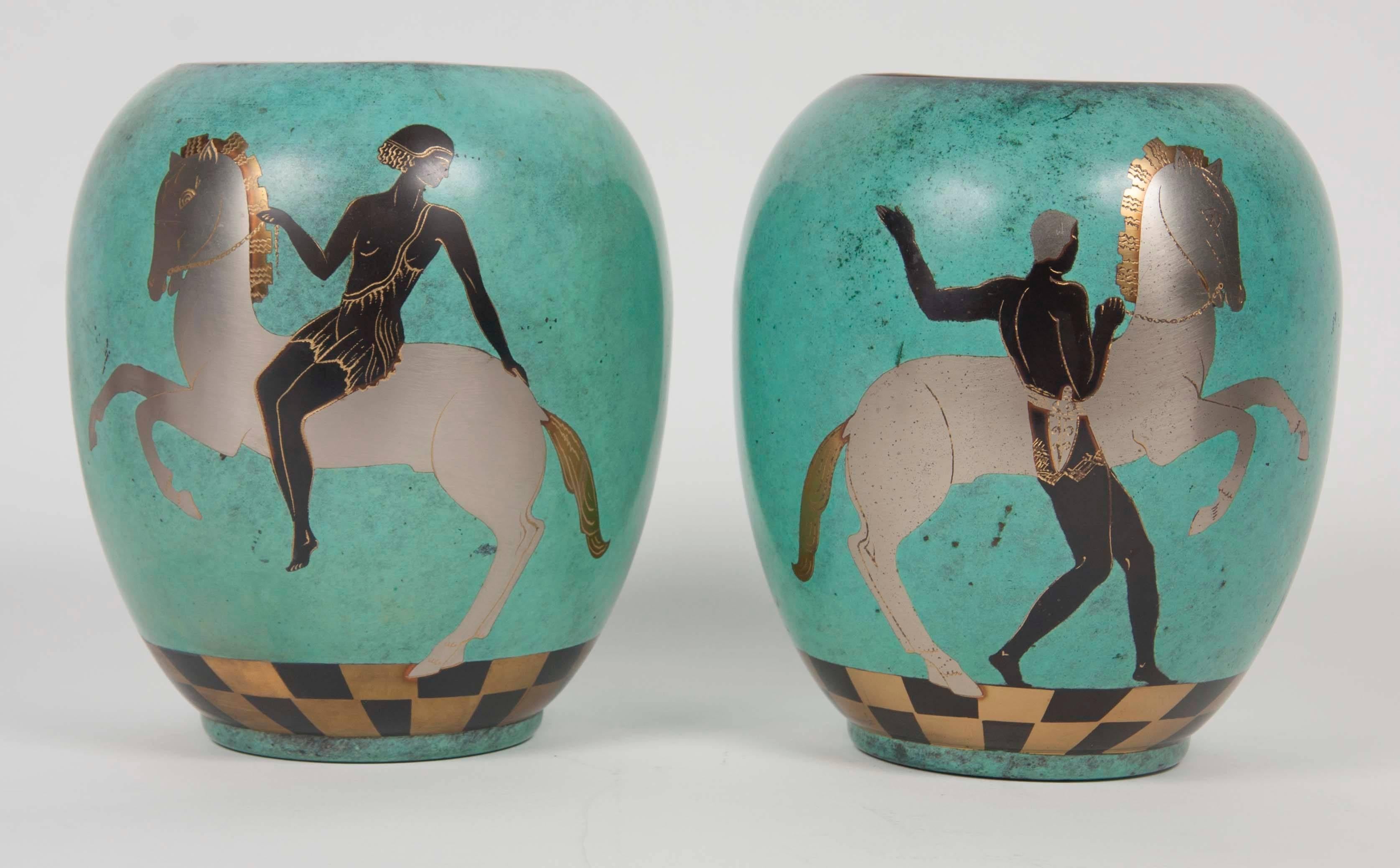 A pair of WMF enamel on copper vases of turquoise with silver, black and gold decoration of mythological figures; one depicting a man with horse, the other a woman riding a horse.