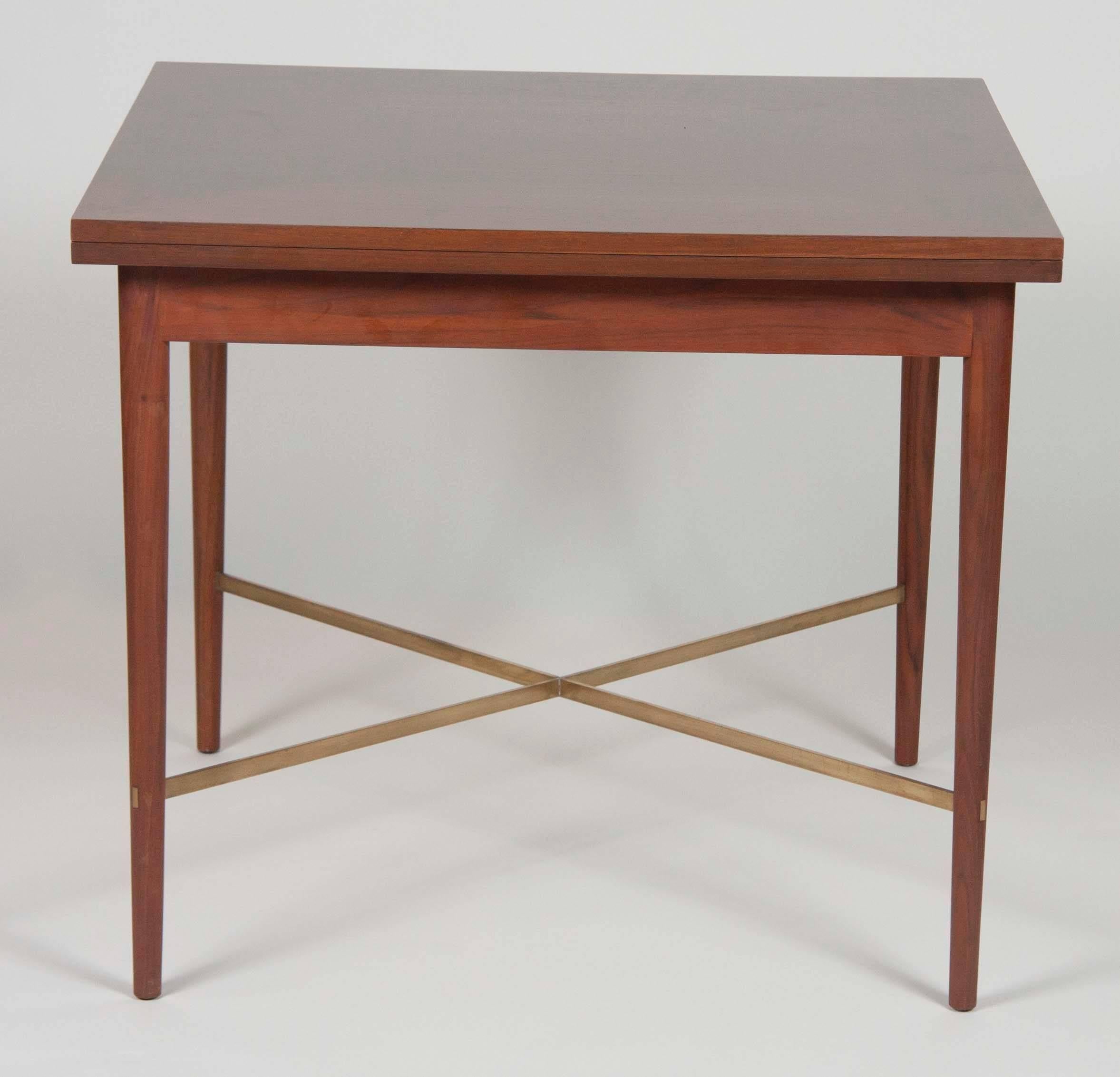 A Paul McCobb walnut card table with folding top. Top opens to be 68 1/4."