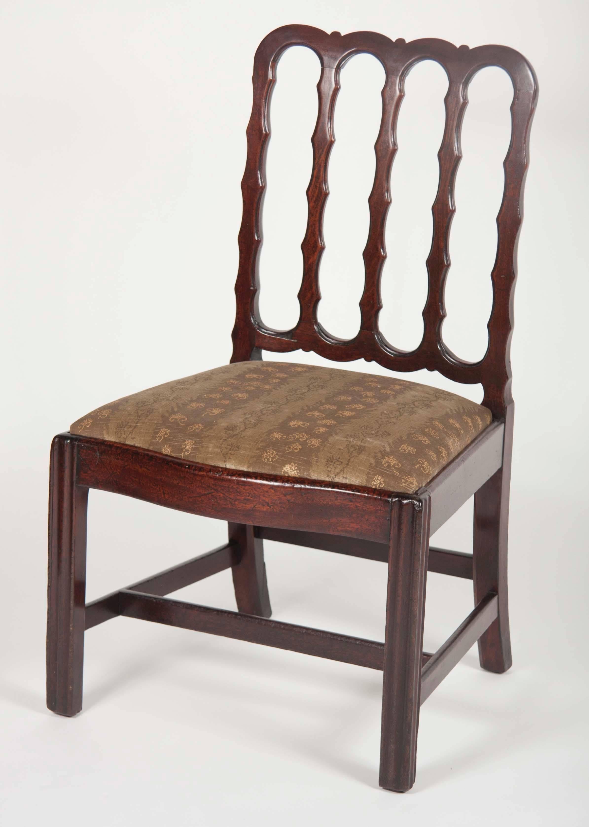 A George III period side chair of square form with serpentine crest and five undulating splats. This chair is most likely a Chinese Export chair in the English taste made of Padouk wood.
   
 