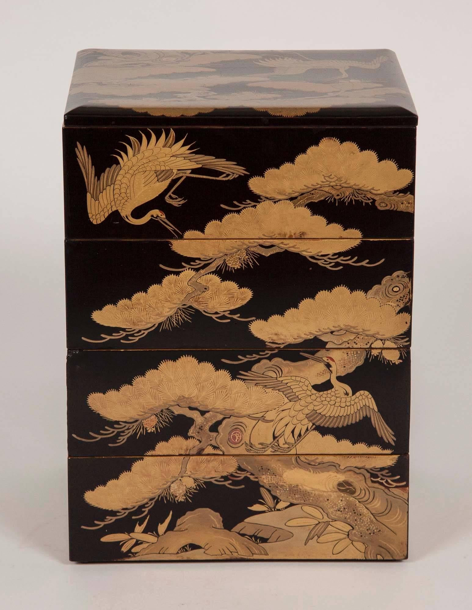 A four-tier Japanese Meiji period black lacquer Jubako box with stork and fir tree decoration. Box in four sections with lid.