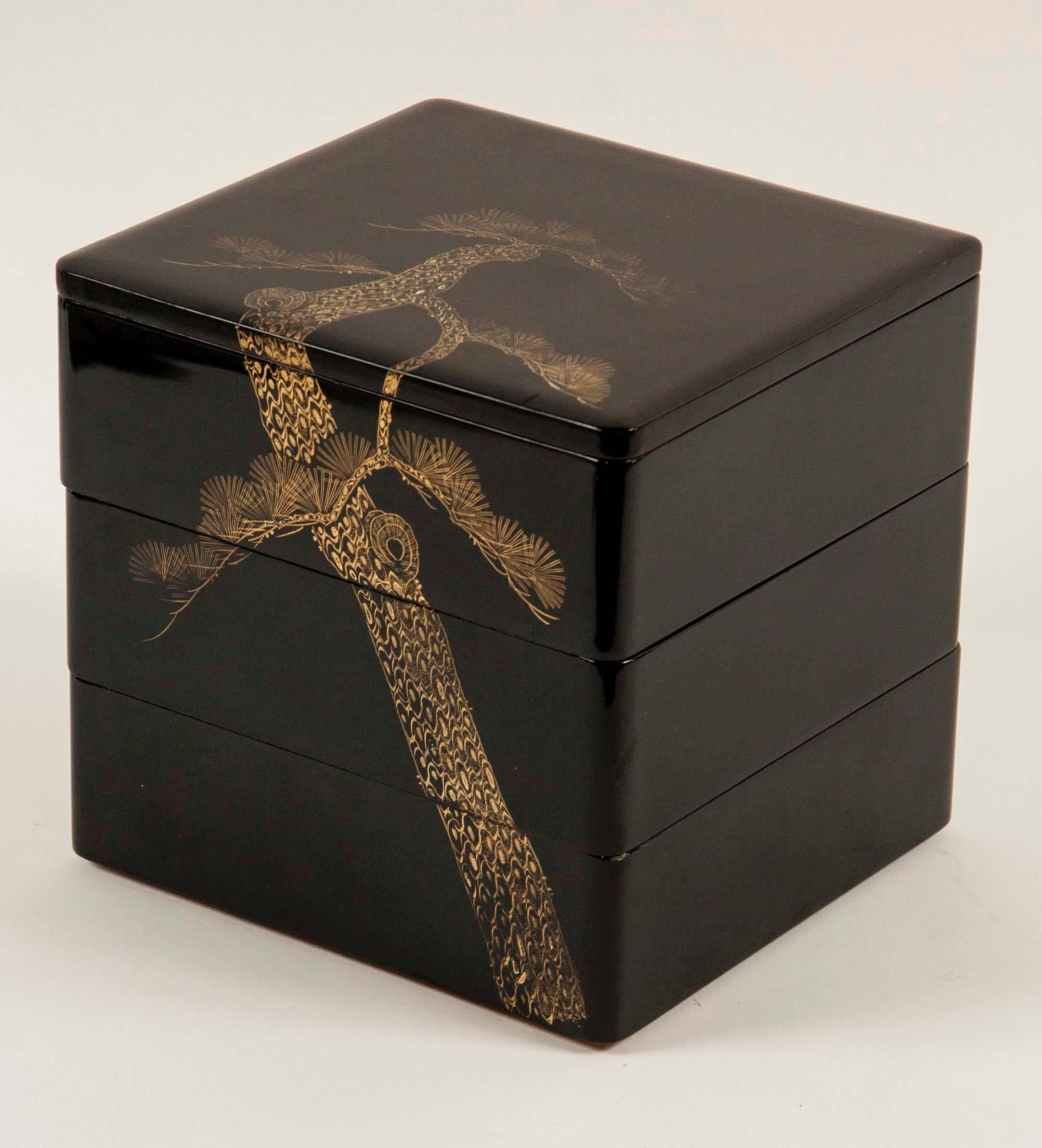 A Japanese Showa black lacquer bento box with gilt pine motif in three parts with lid.