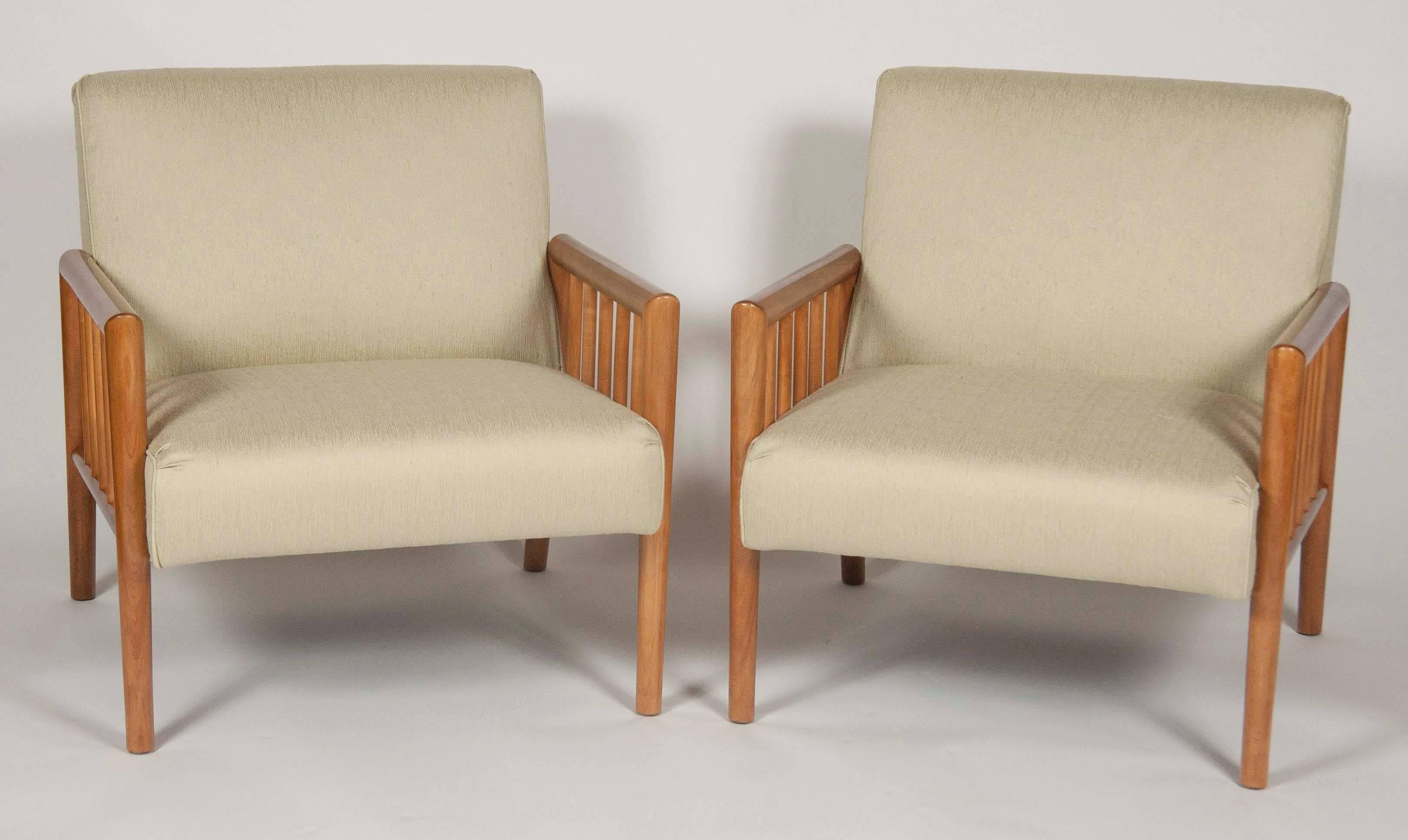 A pair of bleached walnut open-arm chairs in the manner of Gibbings. Fully restored and upholstered in Rogers & Goffigon fabric. The seat height is 17