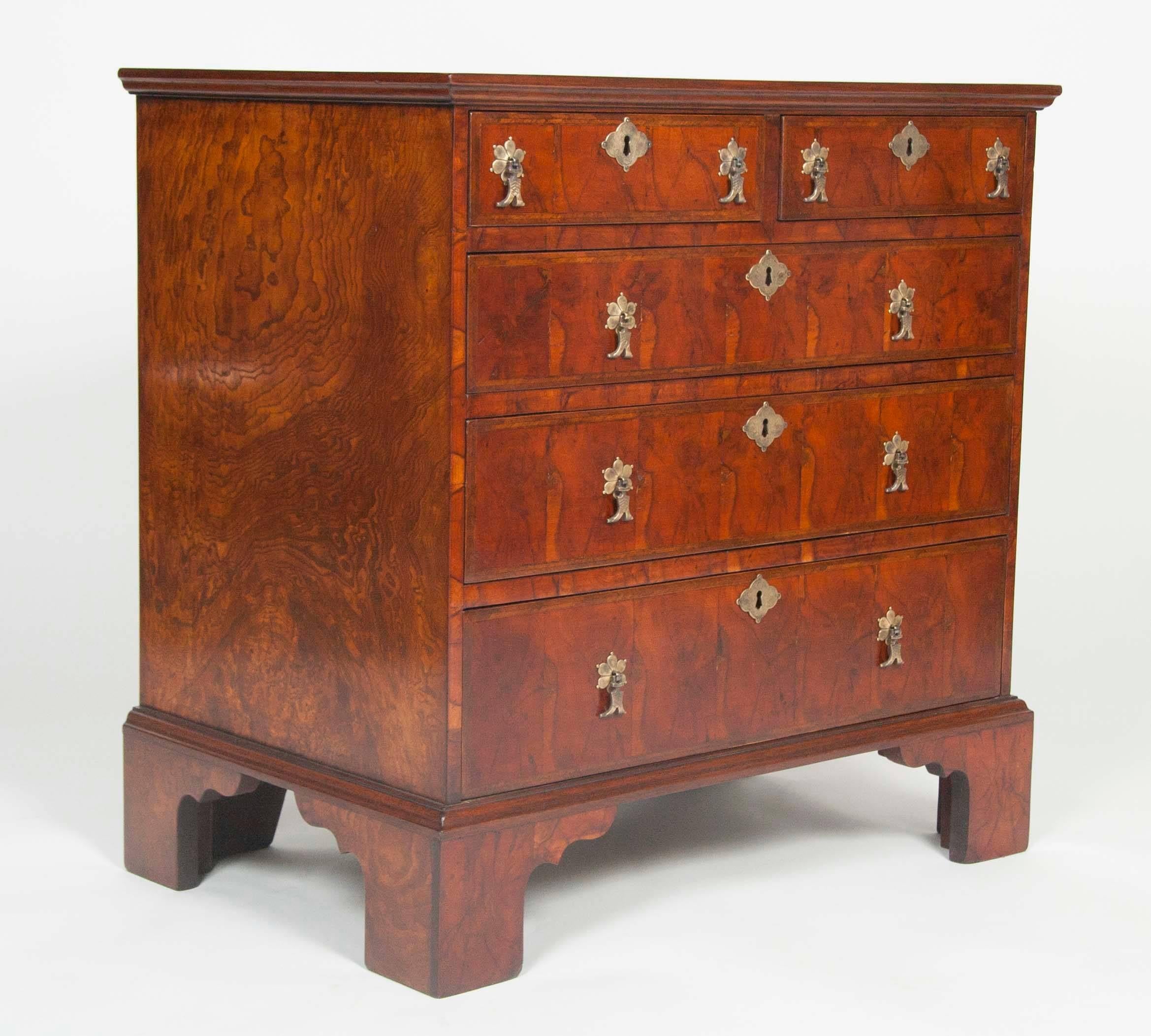 A pair of English oyster shell veneer chests of drawers. Fruitwood, crossbanded with feather band inlay on the tops and feather band inlay to drawer fronts all on bracket feet. May be sold separately.