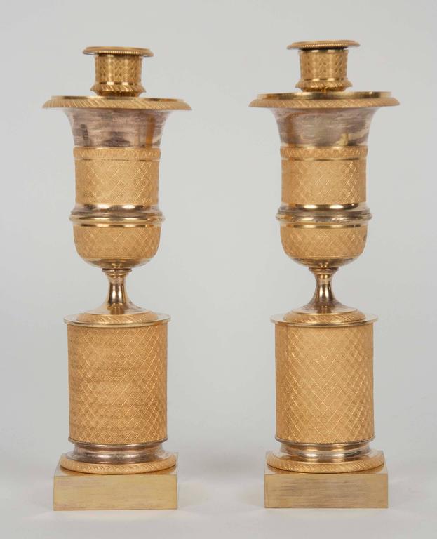 A pair of early 19th century, French ormolu bronze cassolettes. The censers having pierced tops and Candlestick receivers on the revers.