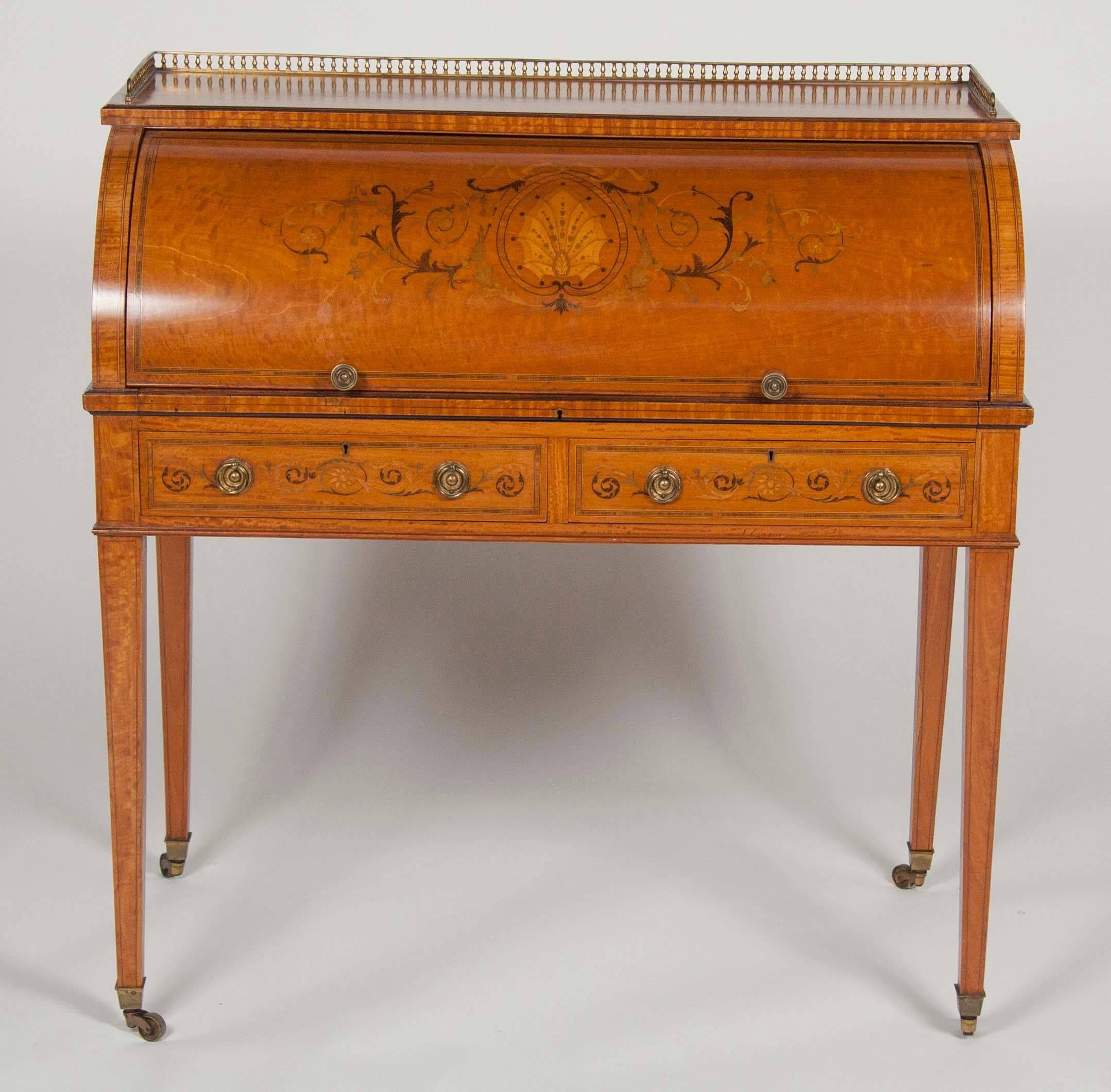 An Edwardian satinwood marquetry inlaid cylinder desk by W.J Mansell.