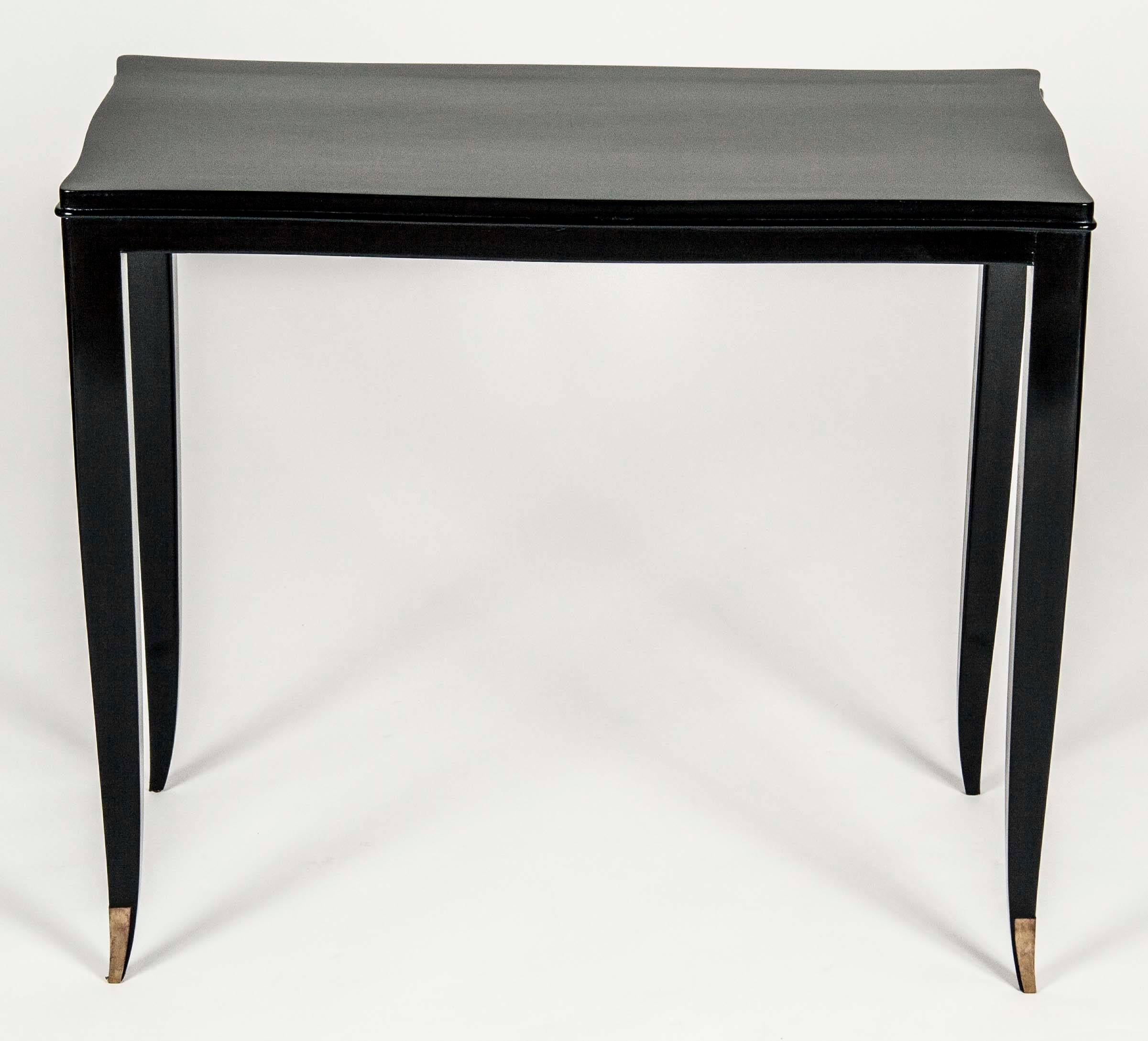 A pair of ebonized beech console tables designed by Andre Arbus. Each leg terminating in d'ore bronze sabot. An example of this console was produced for the women’s sitting room of the Ile De France Pavillion Exhibit at the 1937 Paris Exhibition. 