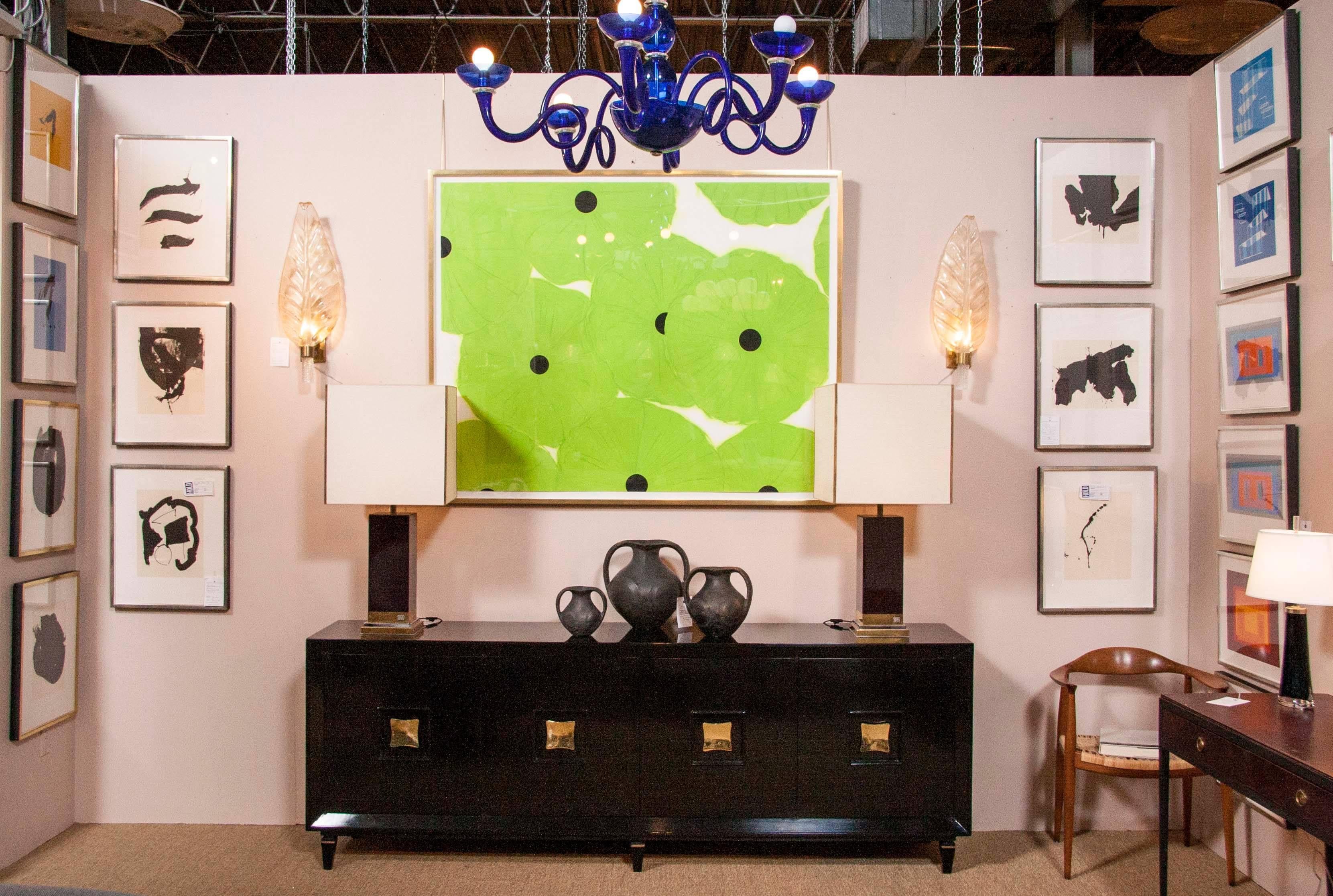 A French Art Deco black lacquer credenza with biomorphic form square brass pulls.