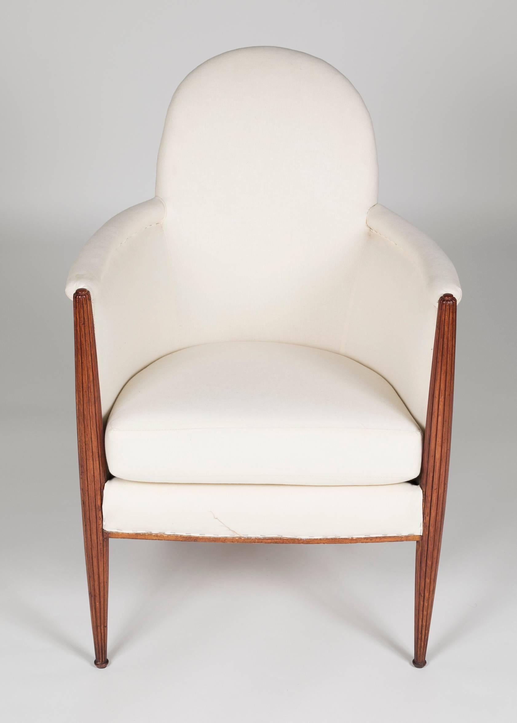 An Art Deco reeded armchair constructed in fruitwood with muslin fabric ready to match your interior.