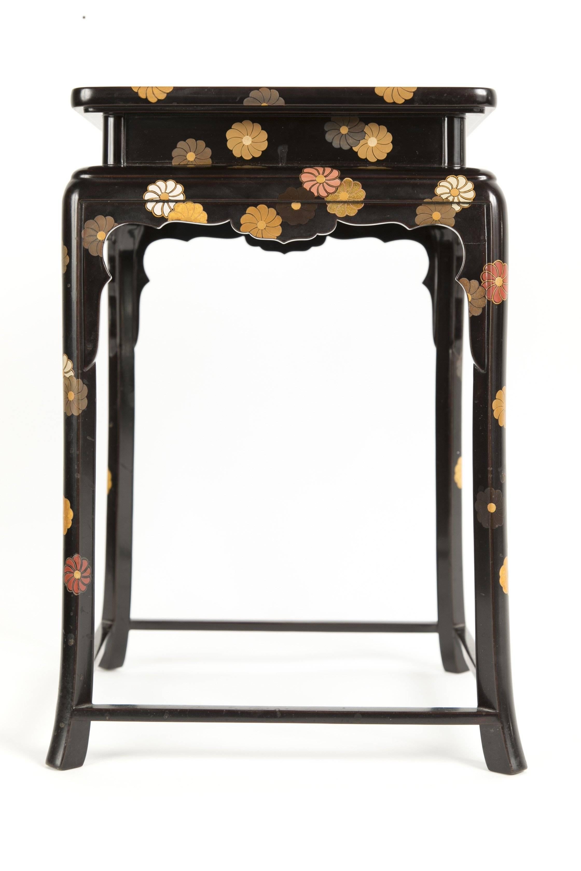 A Japanese black lacquered low side table with Chrysanthemums randomly decorating all surfaces of the table.   Signature to underside of table along with signed Presentation/Storage (Tomobako) Box and cloth storage bag. 