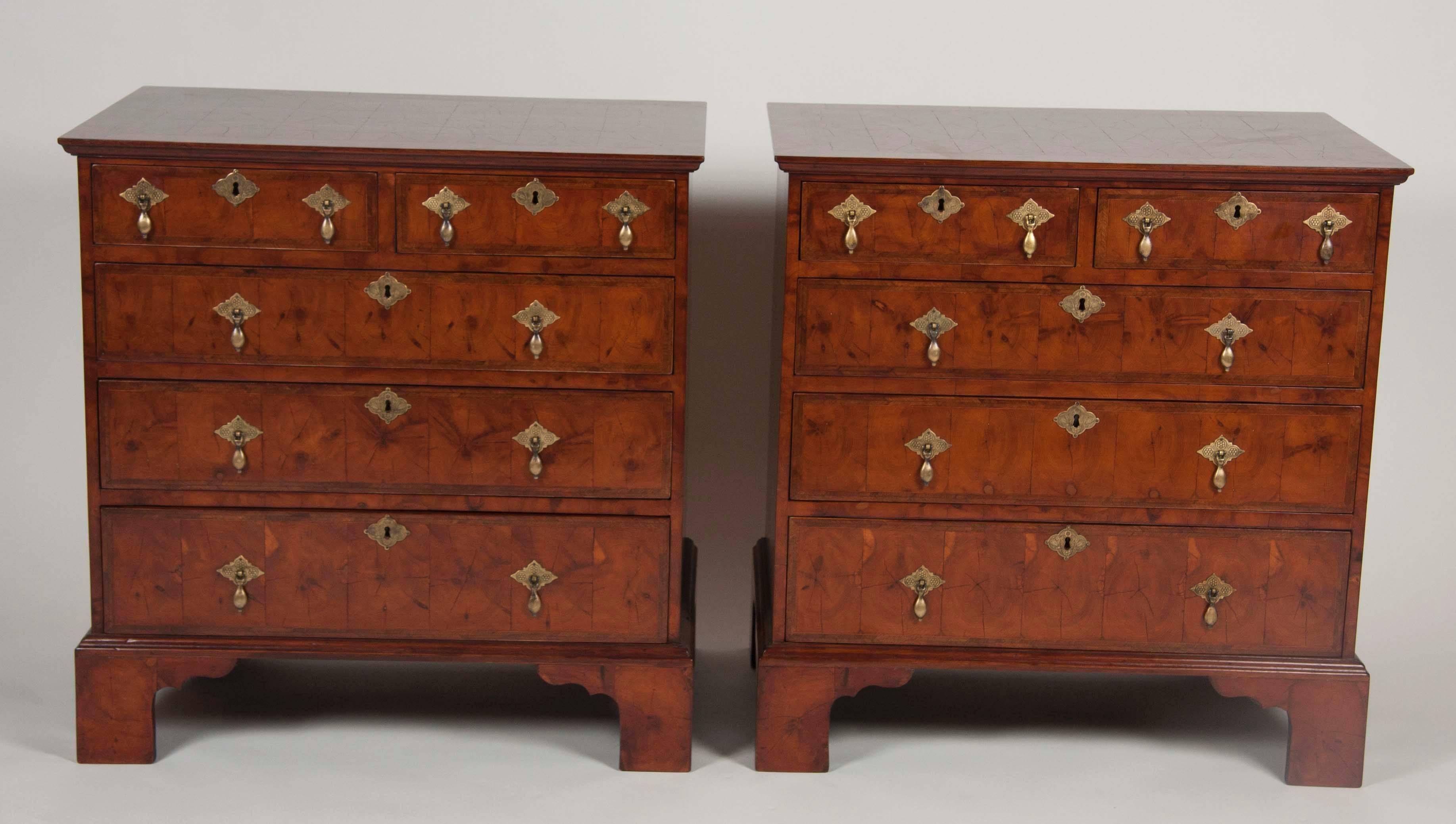 A pair of English oyster shell veneer chests of drawers. Fruitwood, feather band inlay on top and drawer fronts. The top is crossbanded. Bracket feet. May be sold separately.