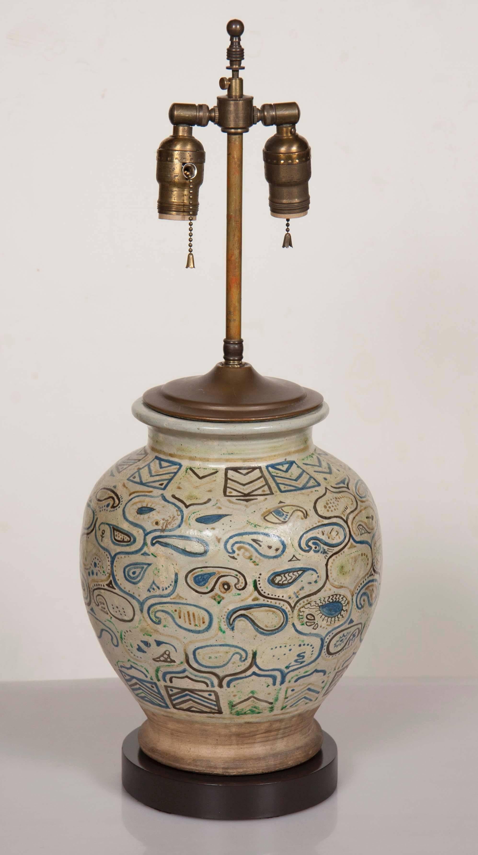 A middle Eastern ceramic or pottery jar now electrified as a table lamp. Height to the top of the jar is 13 inches. Overall height is 24 inches.