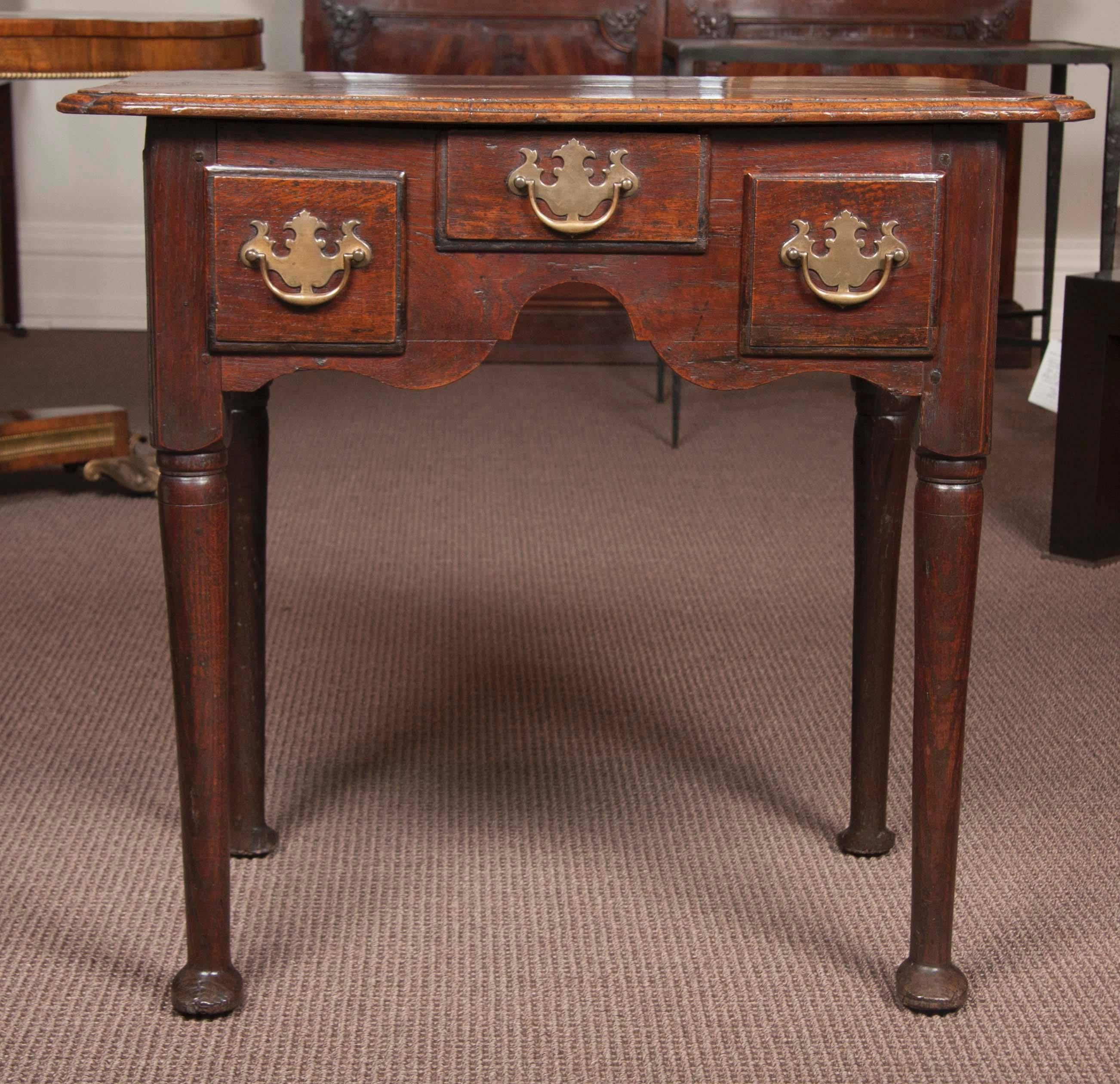 A Queen Anne period oak lowboy or dressing table with three drawers.