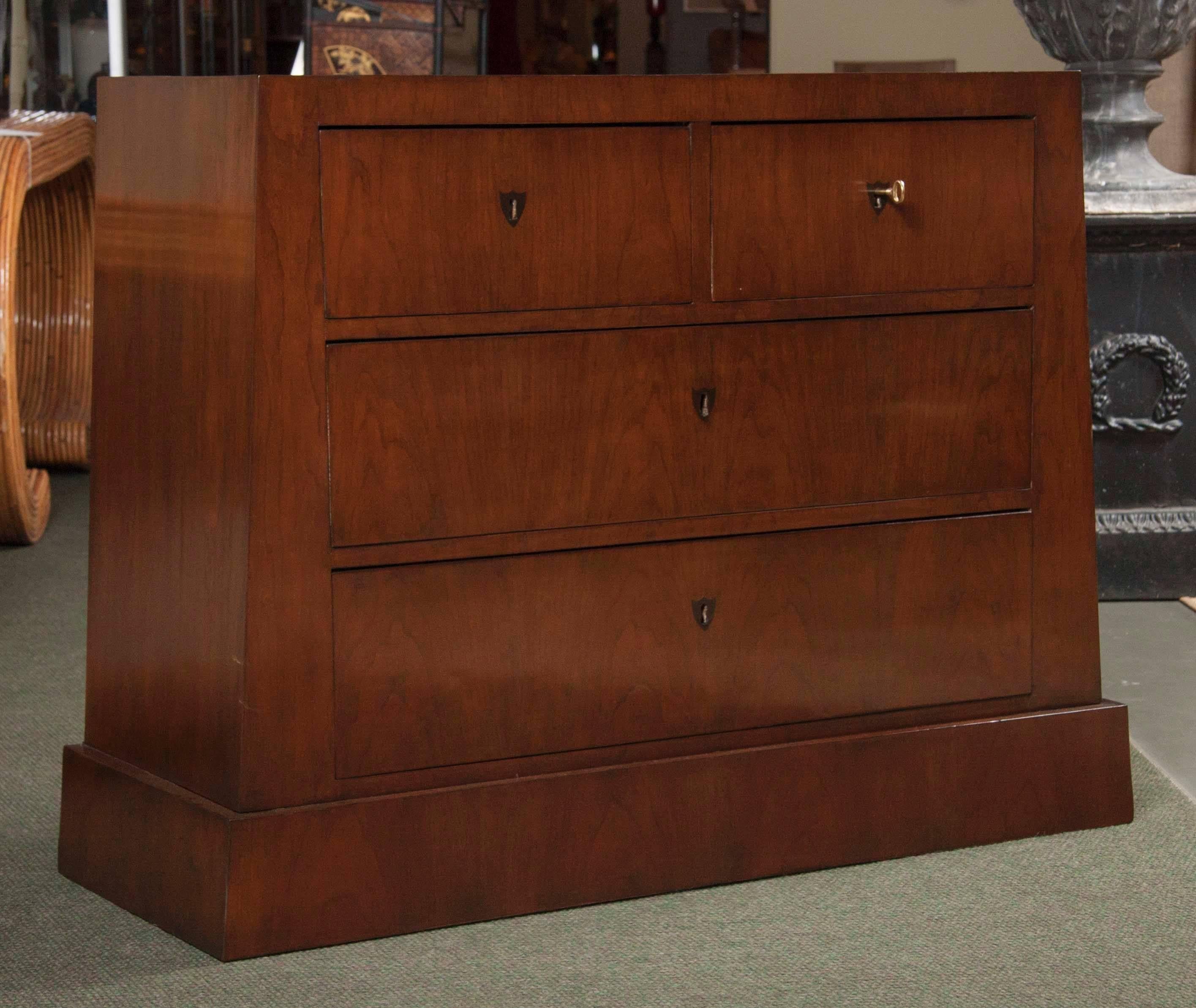 A strong Biedermeier fruitwood four-drawer commode with walnut stain and having angled sides. Fully restored.
